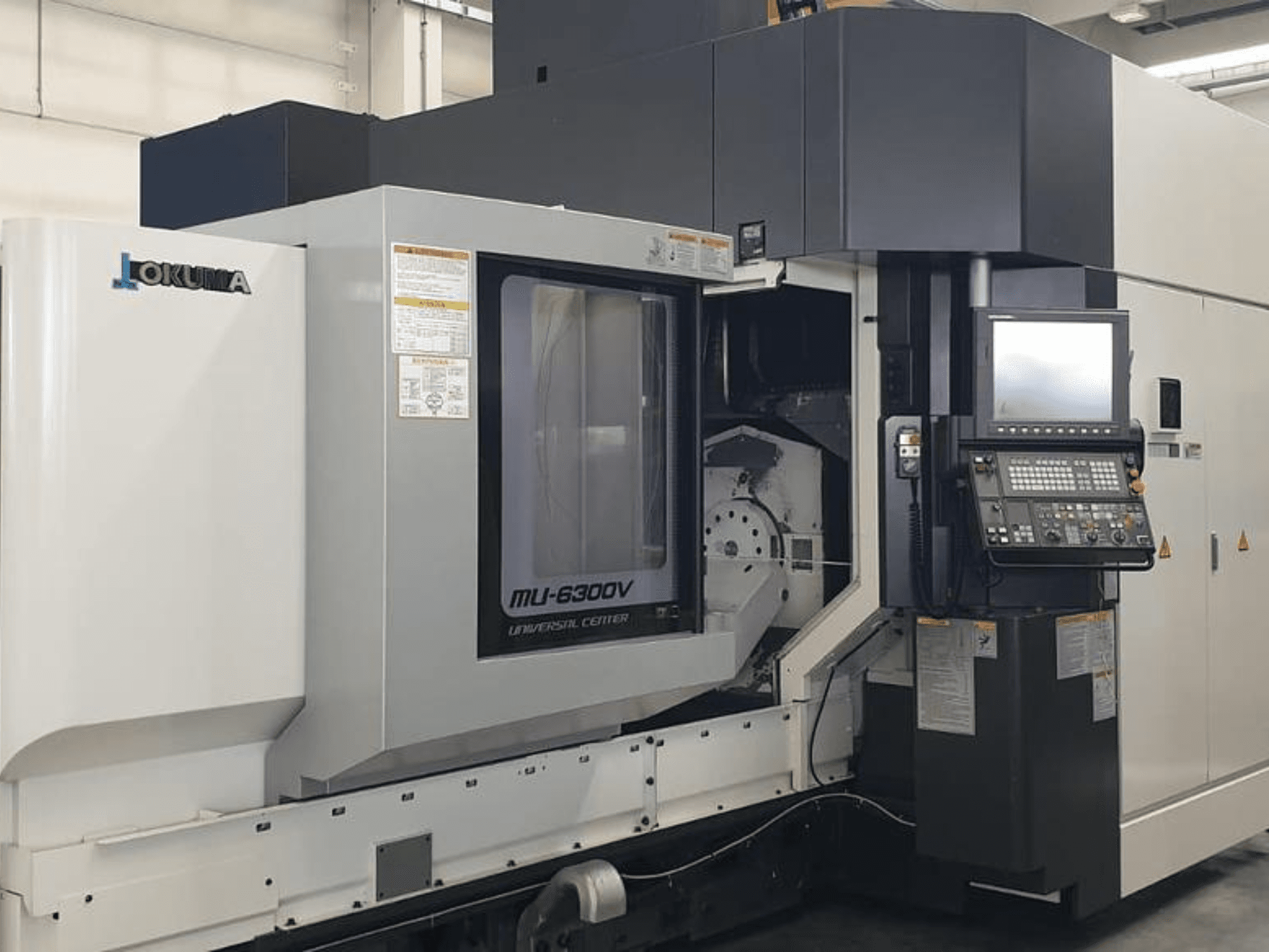 Okuma MU 6300 V vertikalt bearbetningscenter, framifrån med detaljer om kontrollpanelen och bearbetningsområdet.