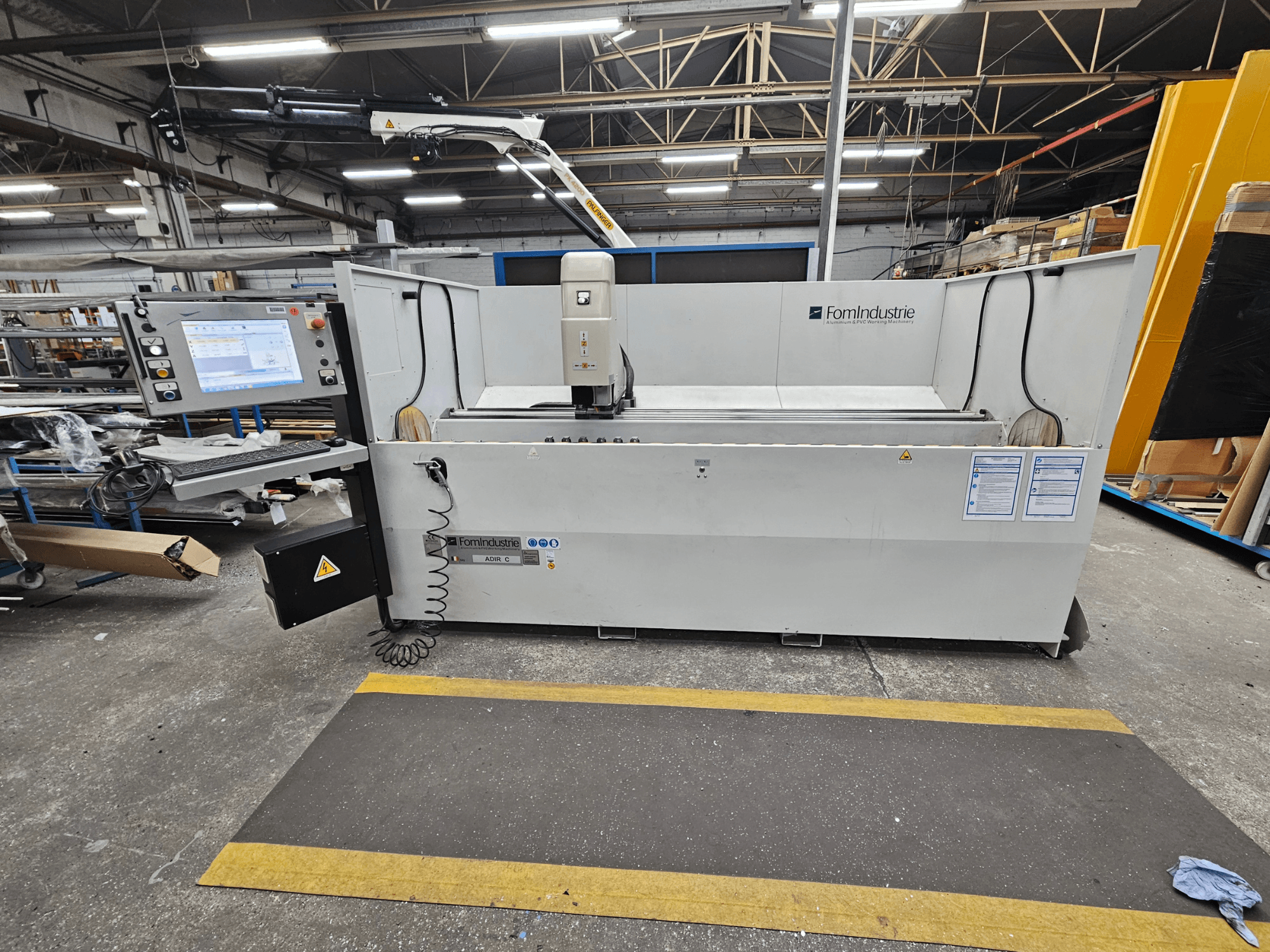FomIndustrie ADIR C vertikal bearbetningscenter i en verkstad, framifrån med kontrollpanel och maskindetaljer.