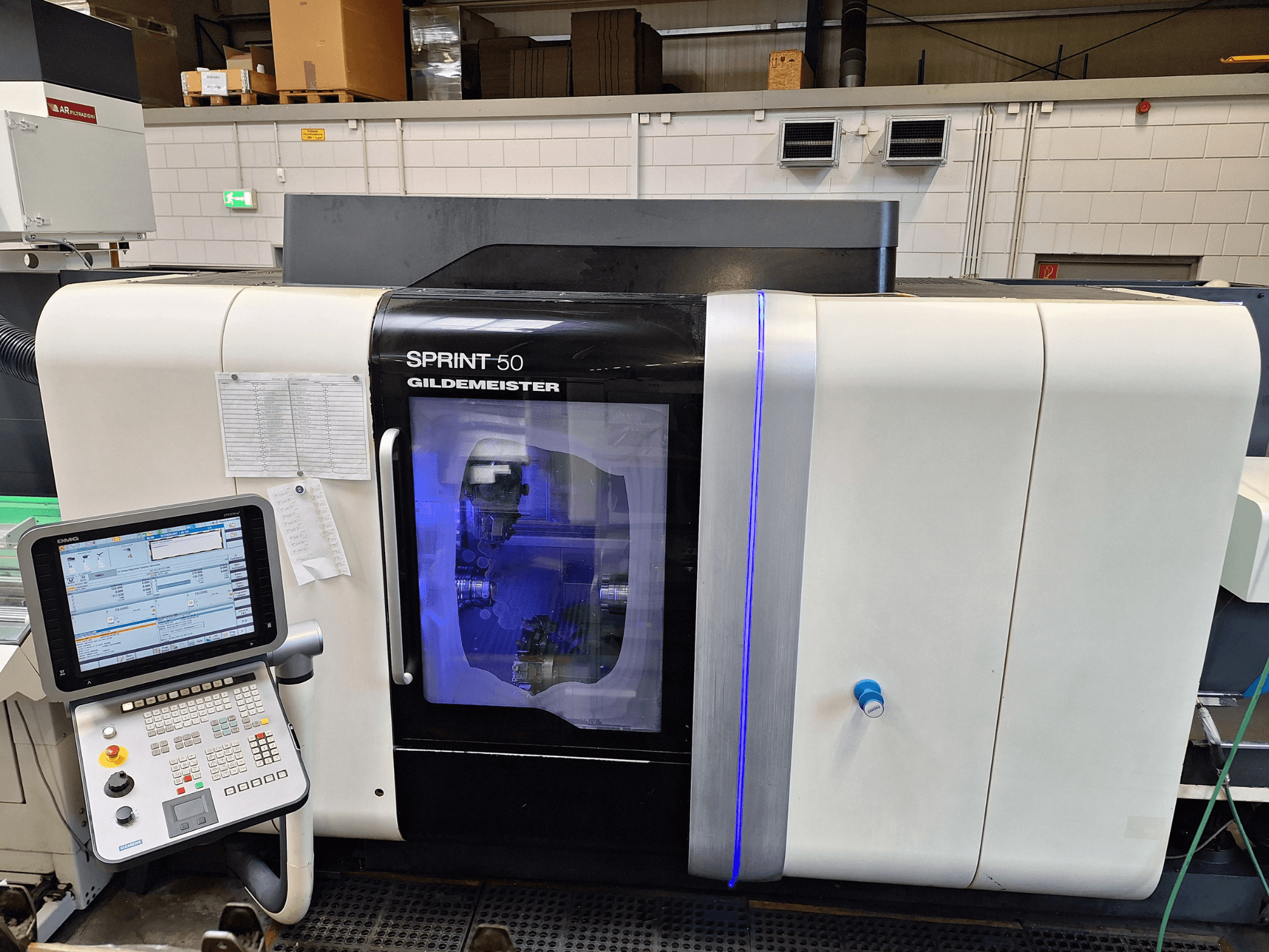DMG Sprint 50 2T horisontell svarv, framifrån, med kontrollpanel och transparent hölje som visar maskinerna inuti.