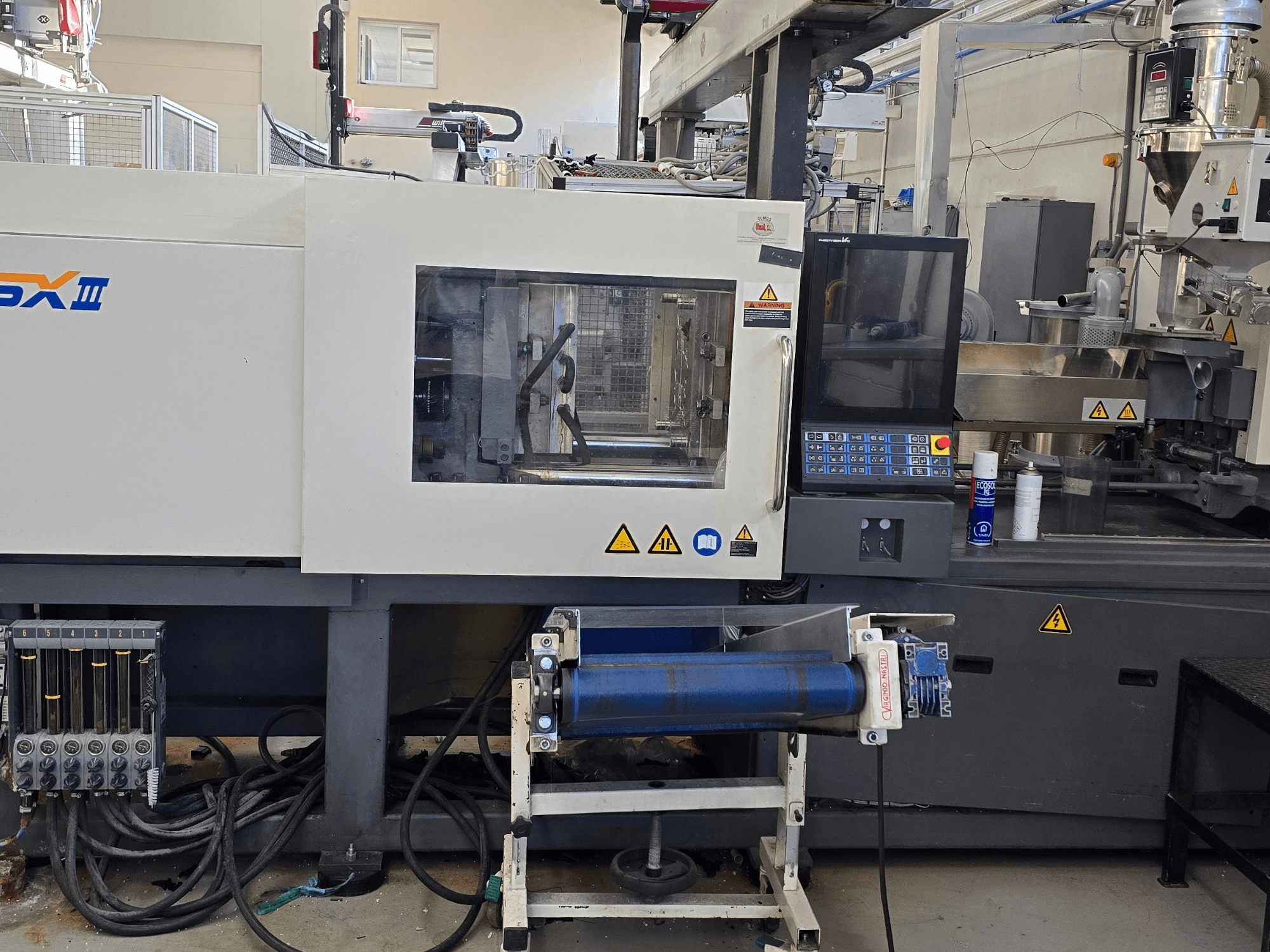 SHIBAURA EC130SXIII-4A elektrisk formsprutningsmaskin, framifrån med kontrollpanel och hydrauliska komponenter.