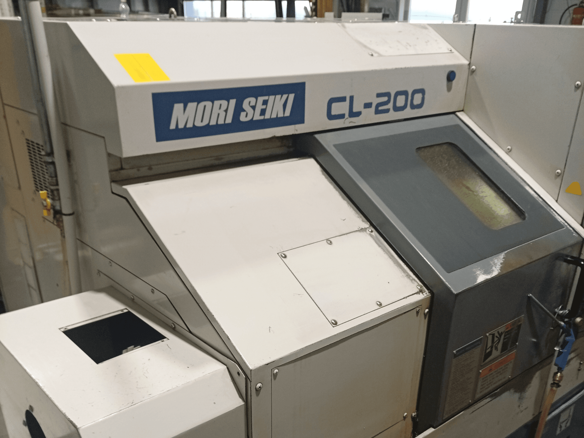 DMG Mori Seiki CL-200B horisontell svarv, framifrån med detaljer från kontrollpanelen och kylmedelsfönstret.