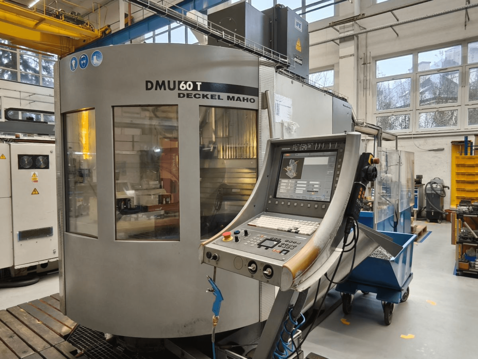 Vertikal vy av DECKEL MAHO DMU 60T bearbetningscenter med kontrollpanel, som visar precisionsverktyg i en verkstad.