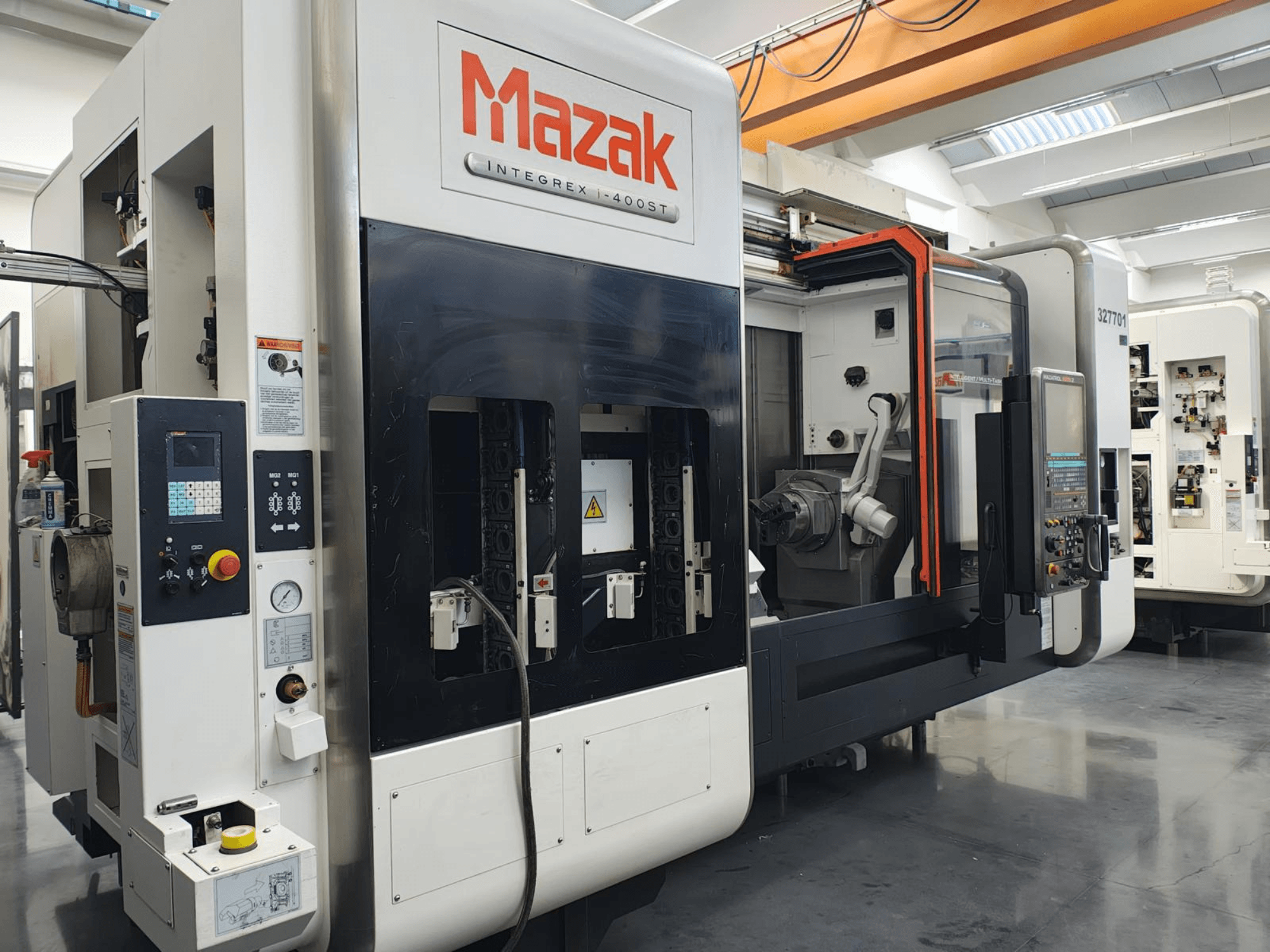 Mazak Integrex 400ST, vy framifrån; CNC-maskin med kontrollpanel, spindlar och robotarm synlig i en verkstadsmiljö.