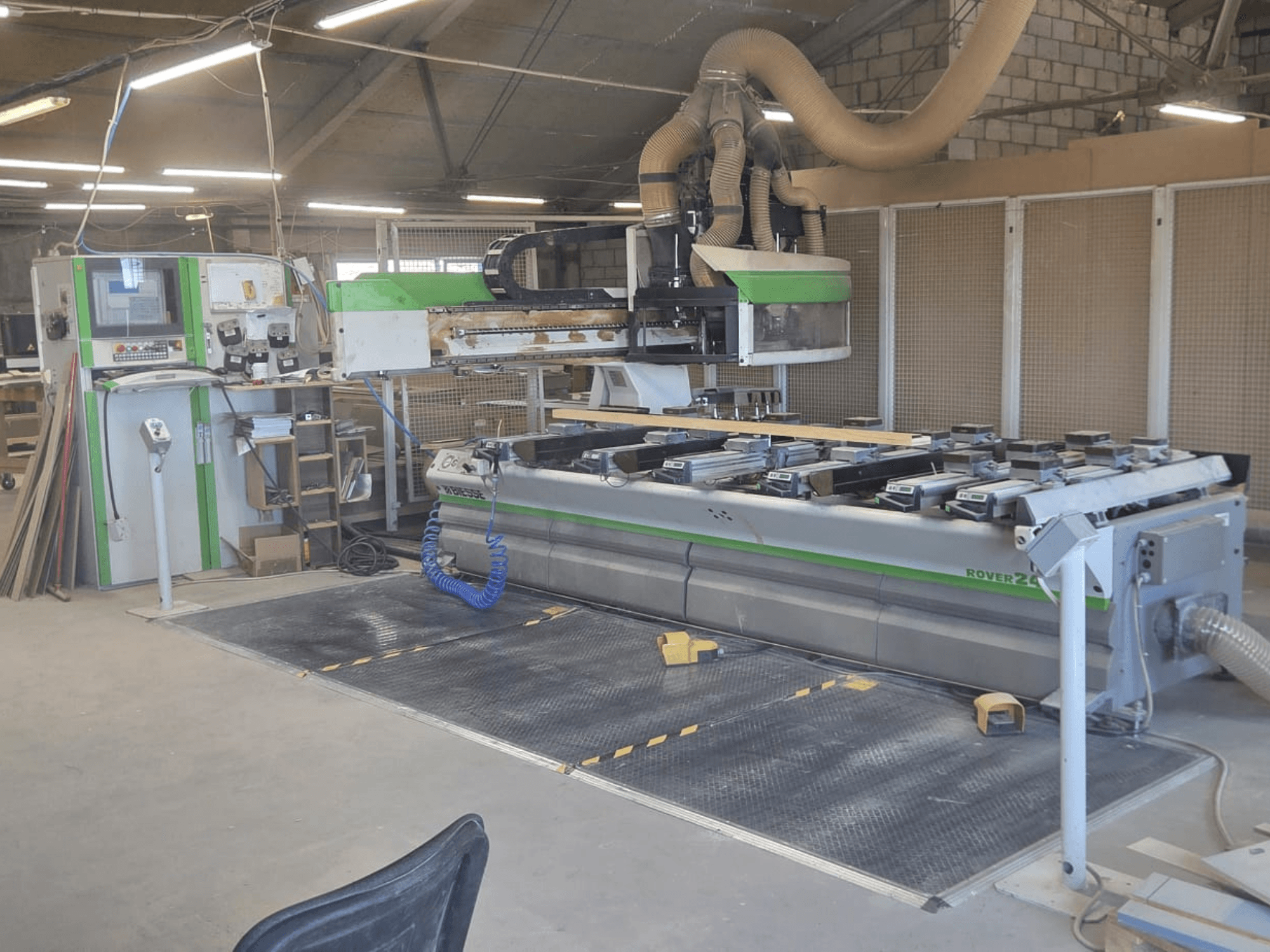 CNC-bearbetningscenter BIESSE Rover 24S i en verkstad, med kontrollpanel och stor arbetsyta med trästycken.