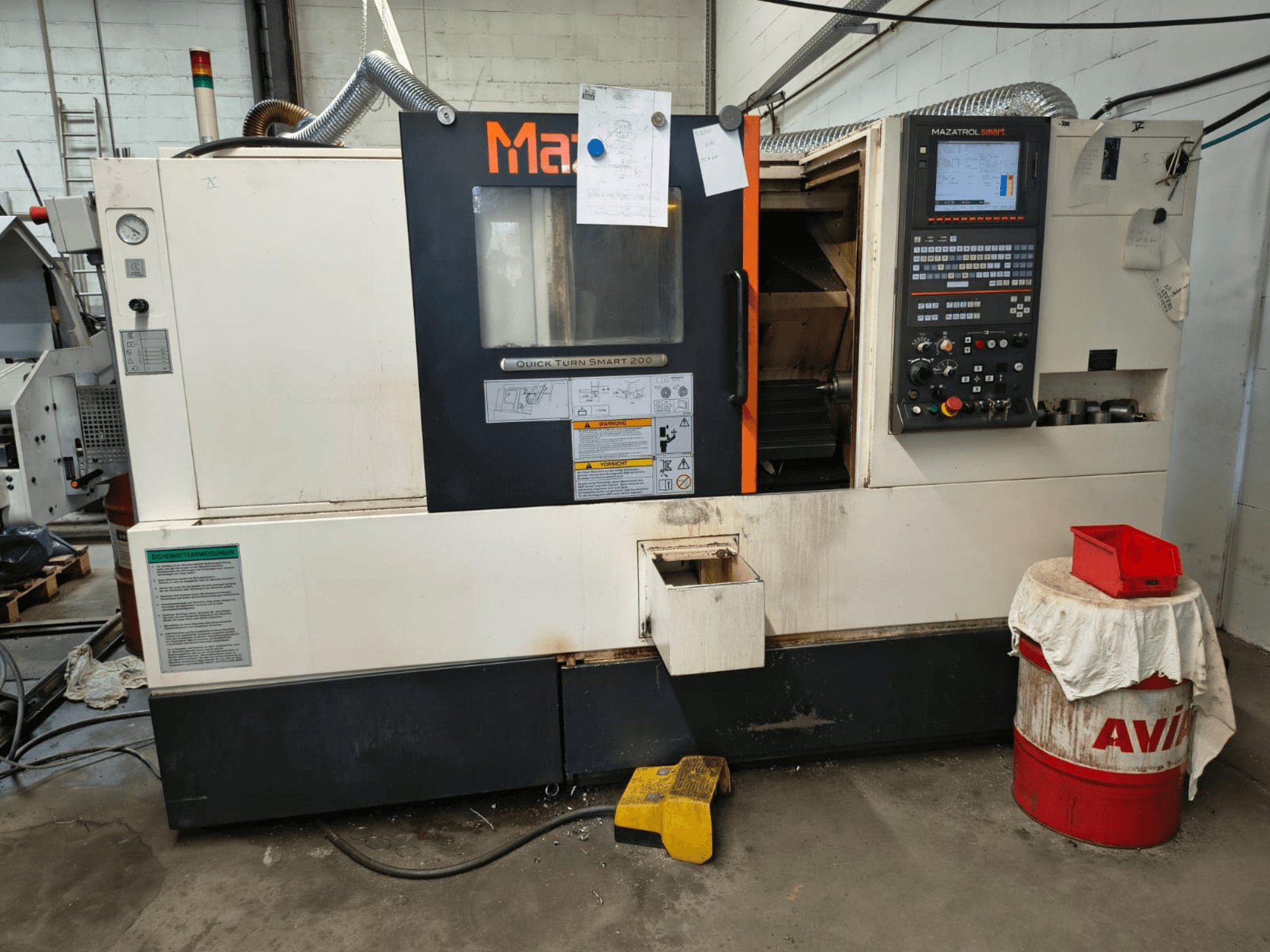 Mazak Quick Turn Smart 200, horisontell svarv, framifrån sett med kontrollpanel, kylvätsketank och markeringar synliga.