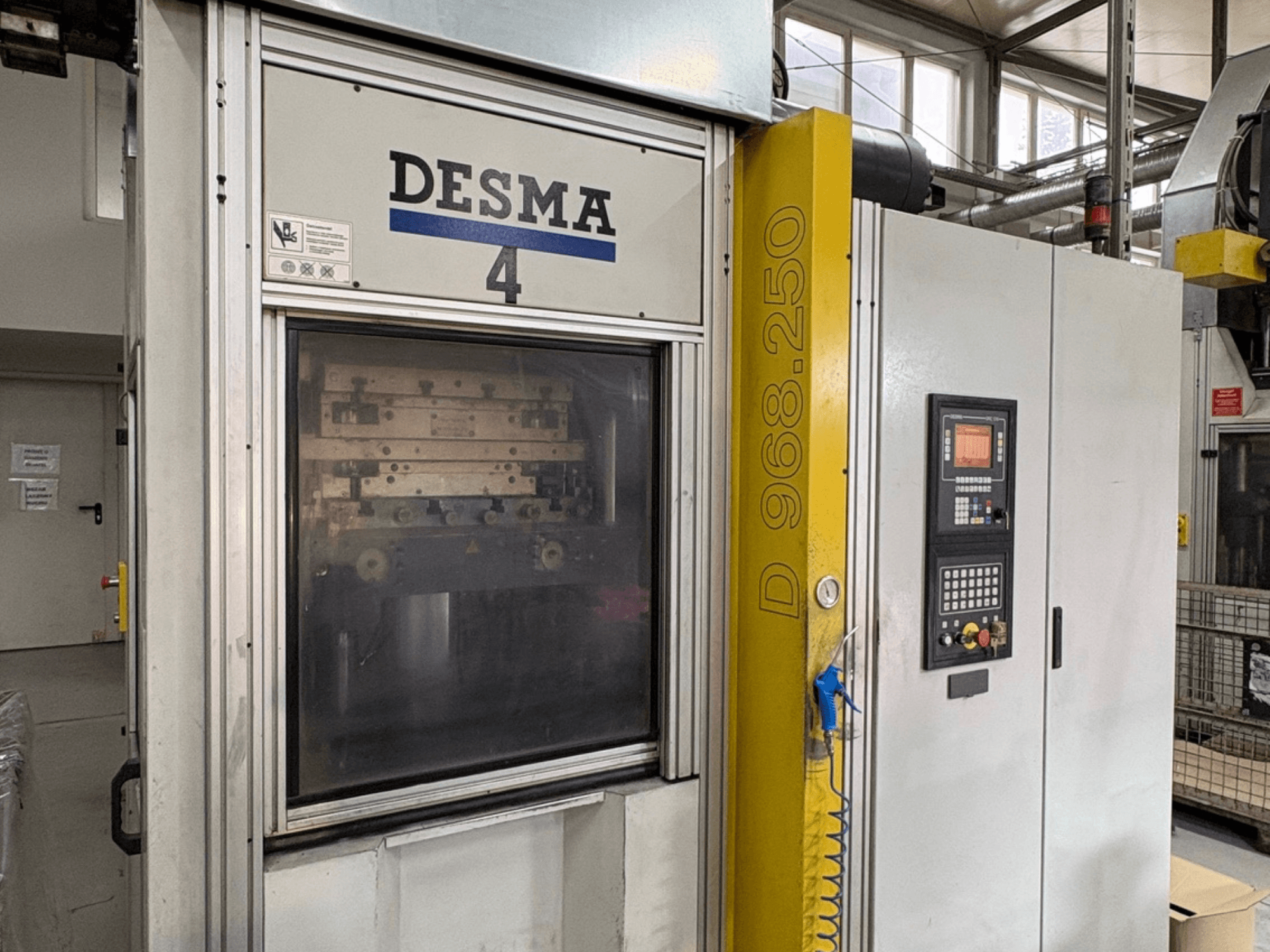 Vertikal formsprutningsmaskin Kloeckner Desma 968.250, framifrån med kontrollpanel och maskindetaljer.