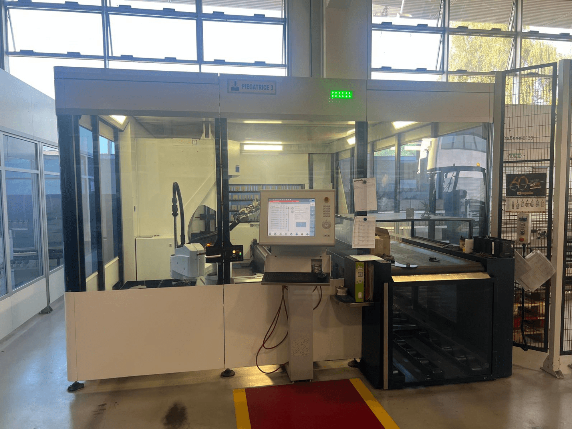 Industriell bockningsmaskin, modell Piegatrice 3, framifrån med kontrollpanel och robotarm, i en väl upplyst verkstadsmiljö.