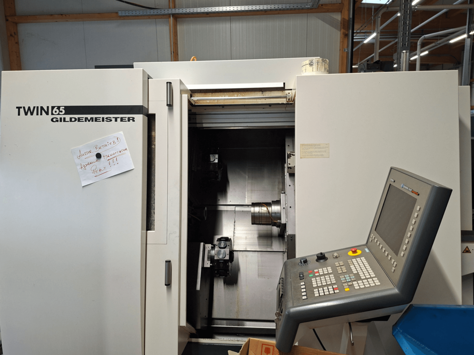 Gildemeister TWIN 65 CNC-svarv, framifrån med kontrollpanel och delvis öppen kammare med synliga maskiner.