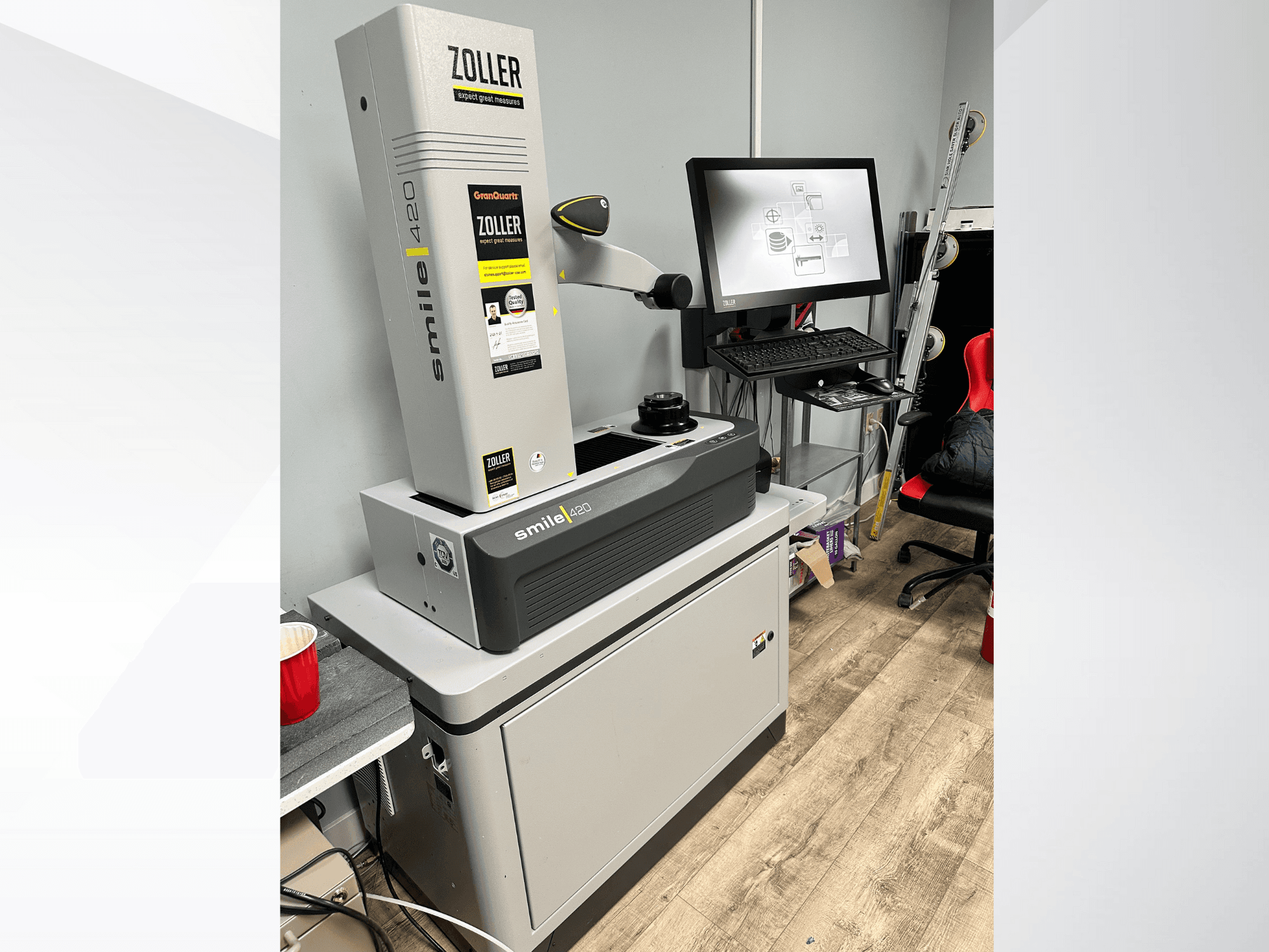 Zoller Smile 420, en digital mätmaskin, visas framifrån med en monitor och arbetsyta i bakgrunden.