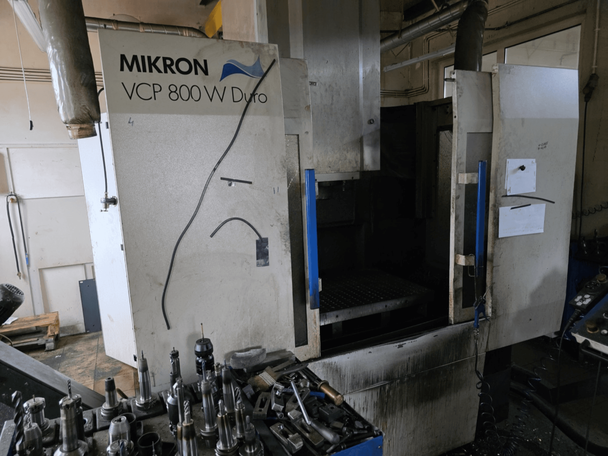 Mikron VCP 800 W Duro fräsmaskin från sidan, med verktyg och reglage synliga i förgrunden.
