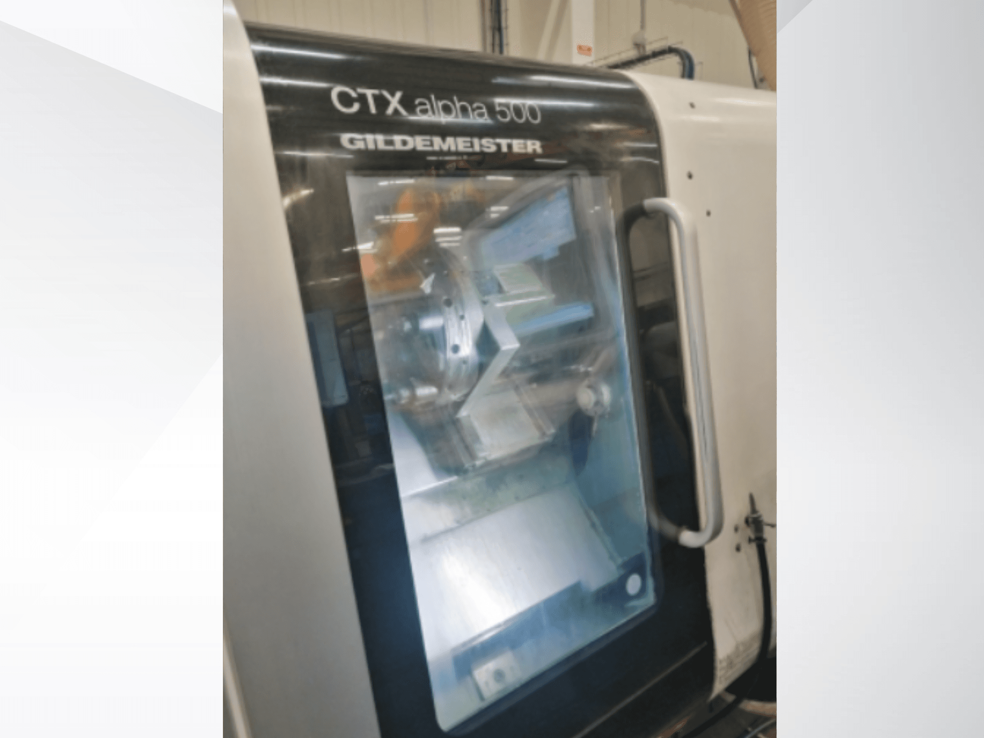 CTX alpha 500 Gildemeister CNC-maskin, framifrån, visar spindeln och bearbetningsområdet genom glasdörr.