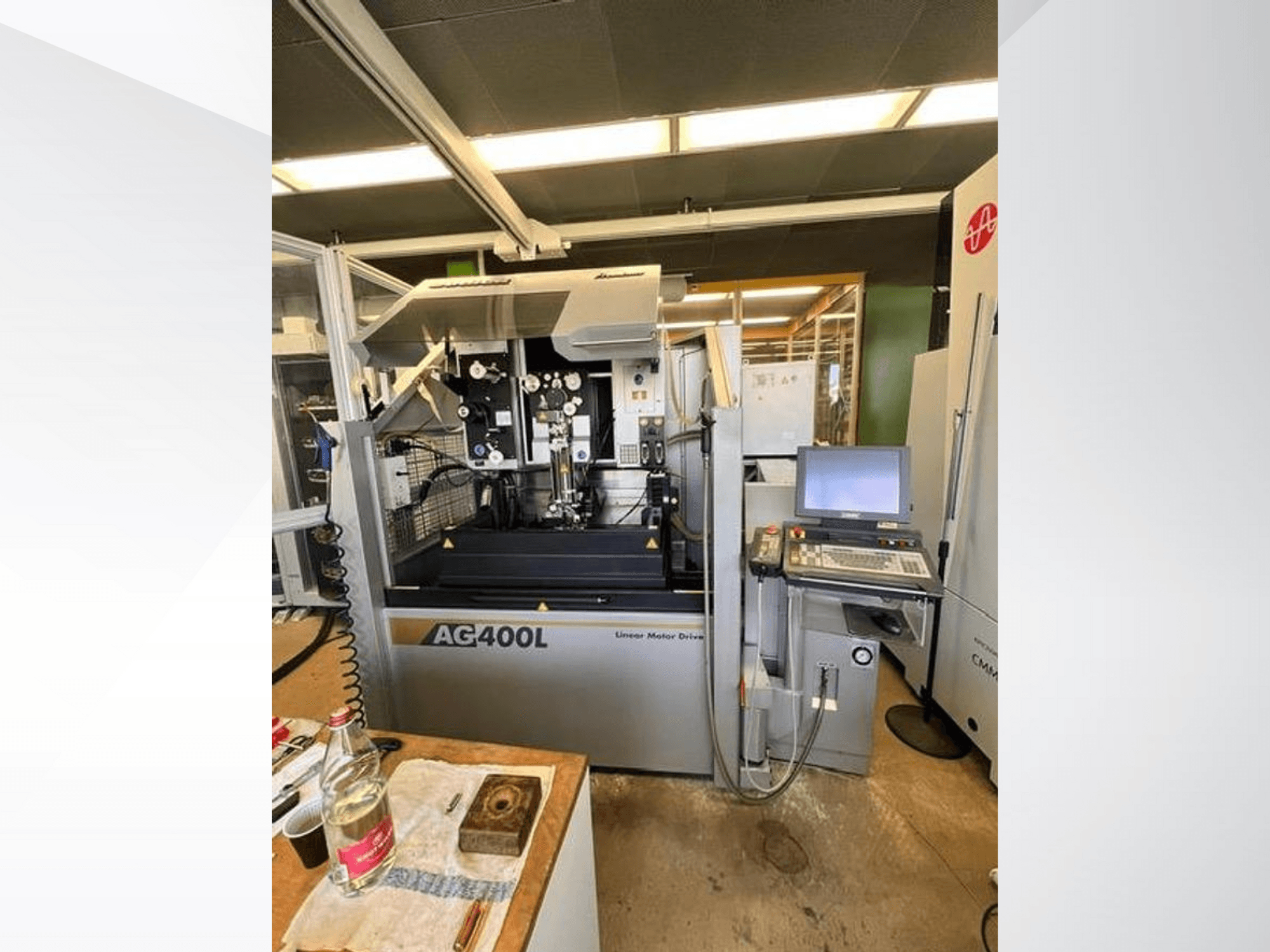 AG400L linjär motordriven maskin, vy framifrån, med kontrollpanel och arbetsområde med synliga säkerhetsfunktioner.