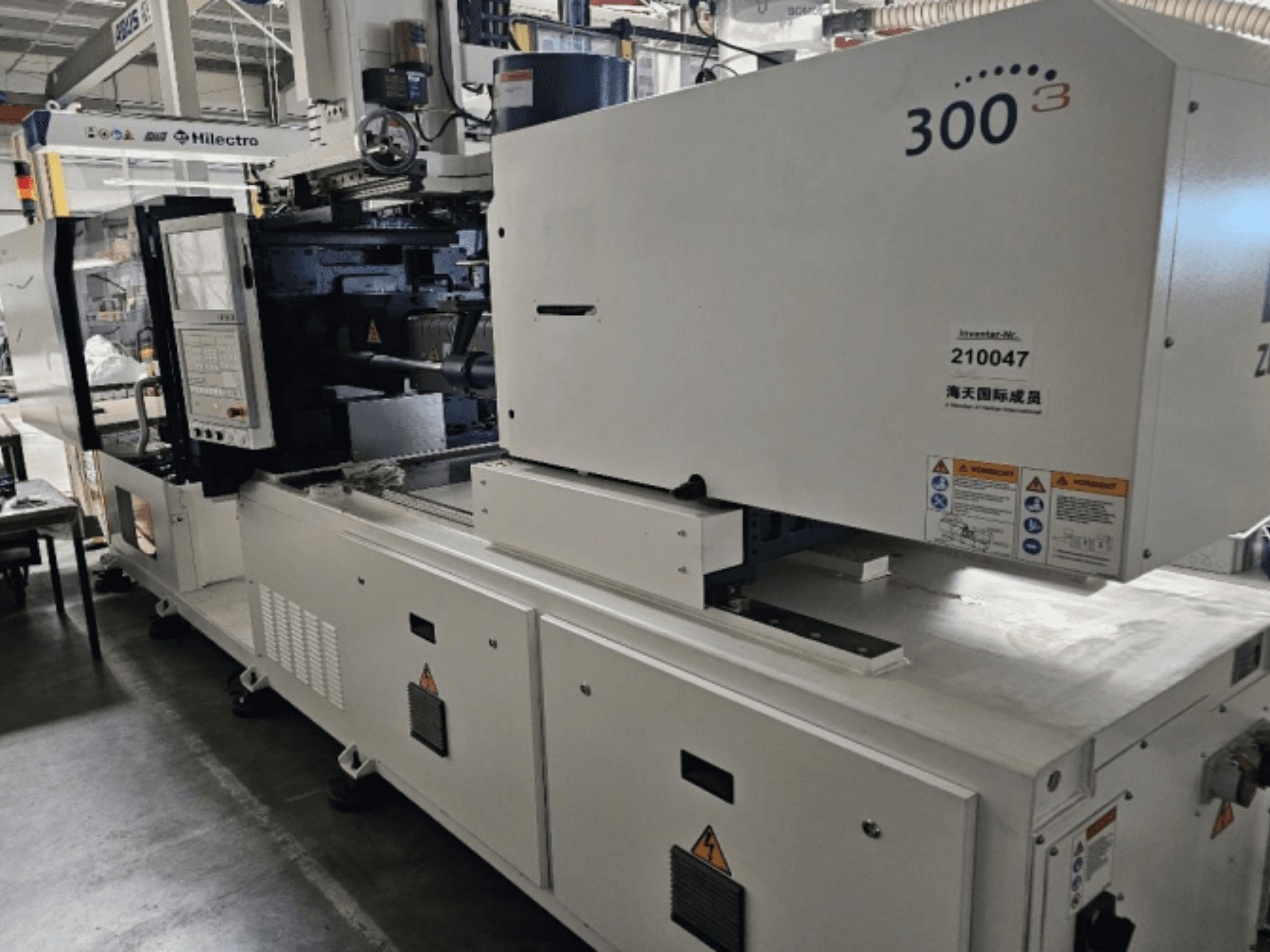 Formsprutningsmaskin, märke Zhenjing, modell 300, framifrån med kontrollpanel och varningsetiketter synliga.