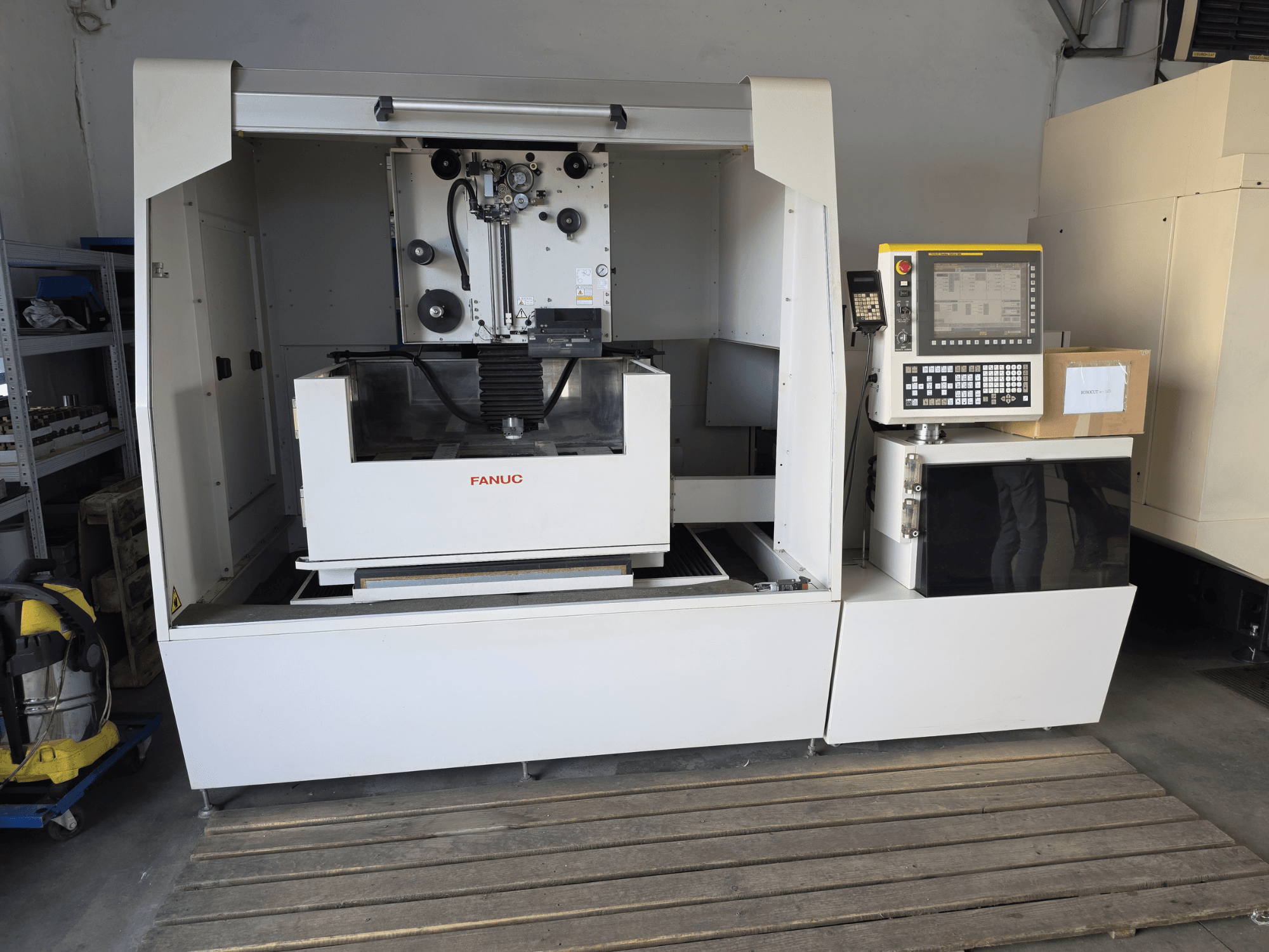 FANUC ROBOCUT alpha-1iD trådgnistmaskin, framifrån sett med kontrollpanel, arbetsområde och kompakt konstruktion i verkstadsmiljö.