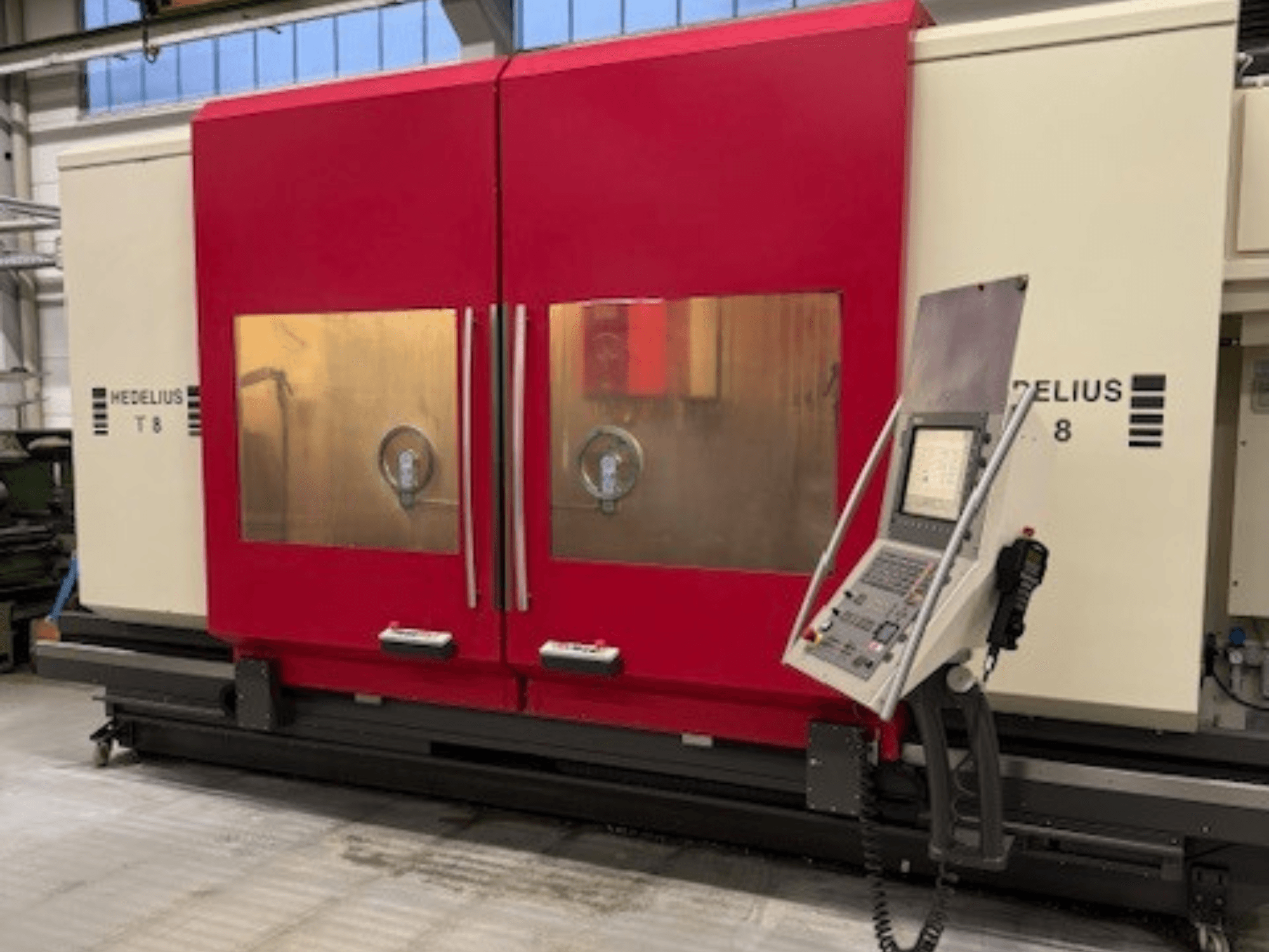 HEDELIUS T8 CNC-maskin framifrån, med röda dörrar, kontrollpanel och synliga interna komponenter.