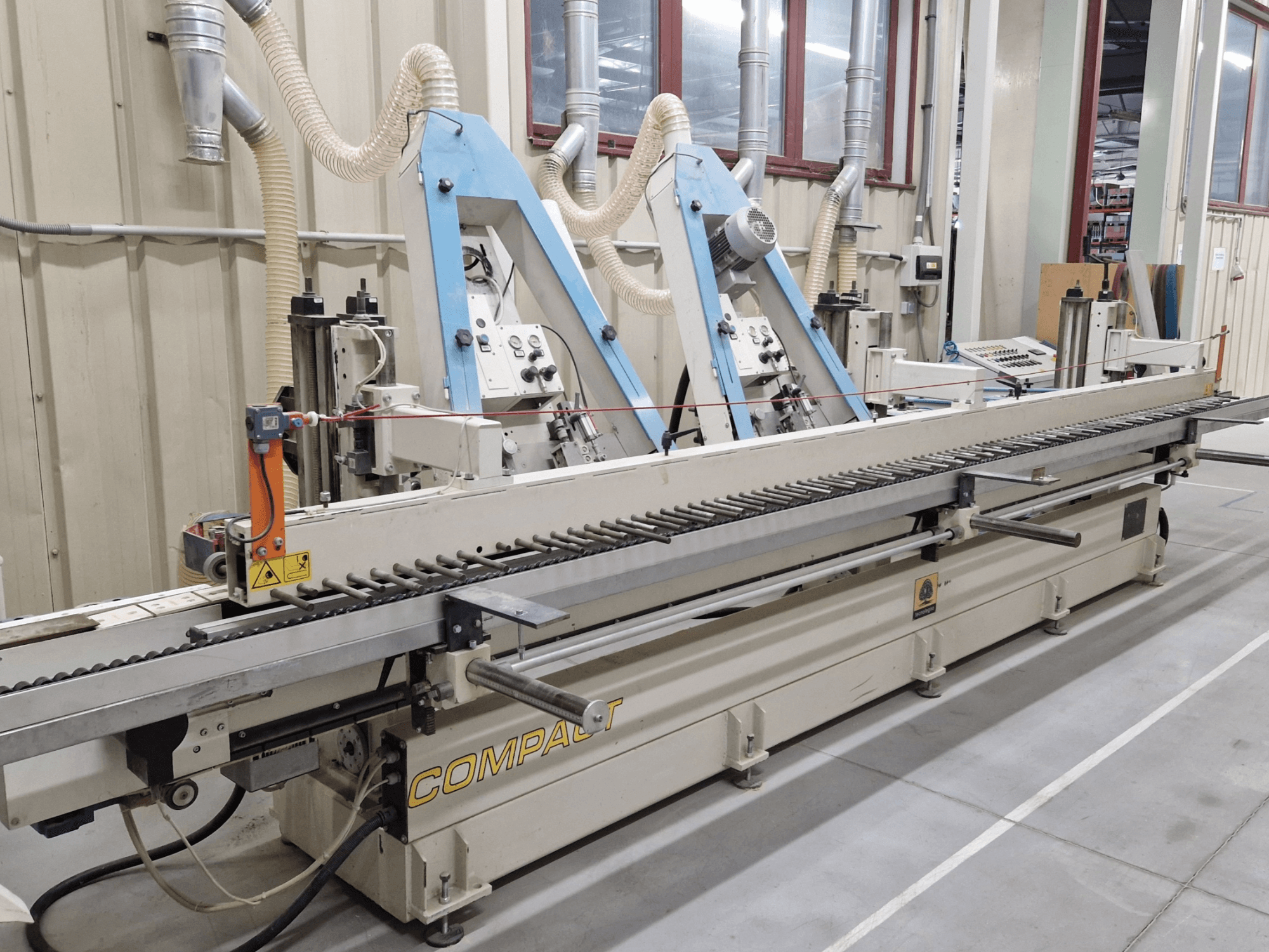 Bandslipmaskin TECNOLEGNO COMPACT 52 i en verkstad, visar kontrollpanelen och slipbandsmekanismen från sidan.