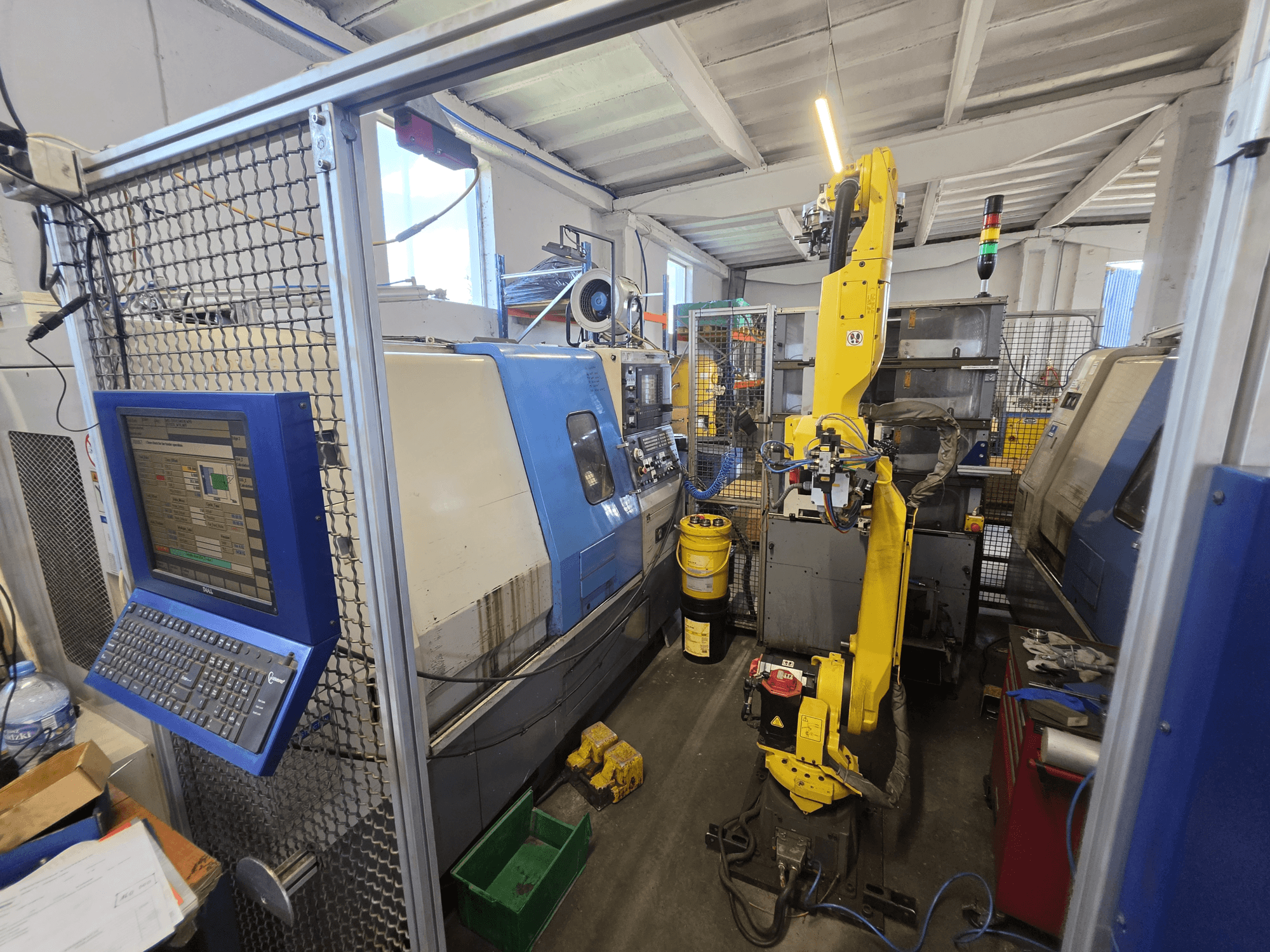 Hyundai HIT-200C horisontell svarv med FANUC M-20iA-robot, framifrån sett med kontrollpanel och maskinens uppställning.