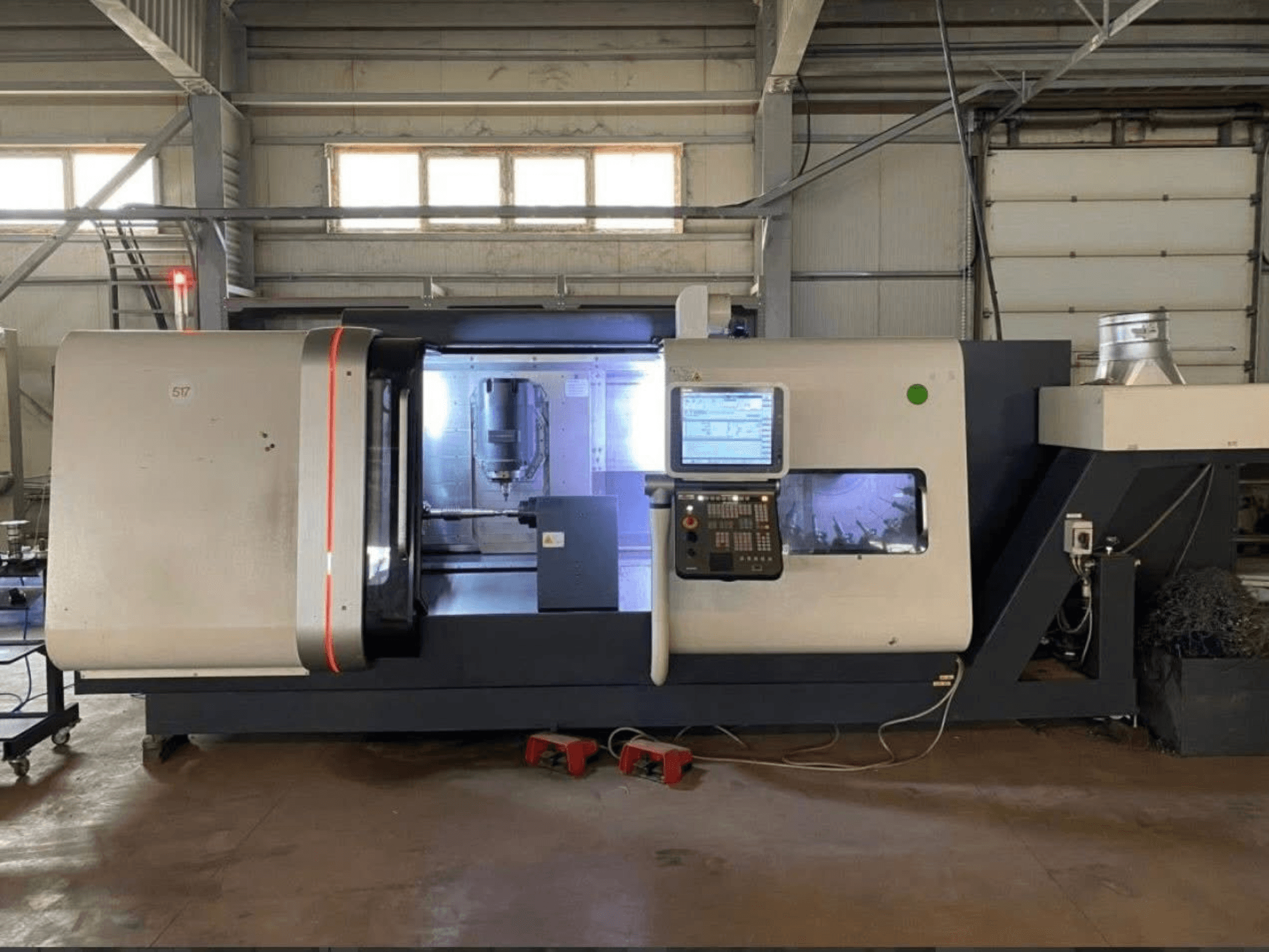 DMG MORI Beta 1250 TC svarv- och fräsmaskin, framifrån med kontrollpanel, upplyst arbetsyta och skärverktyg synliga.