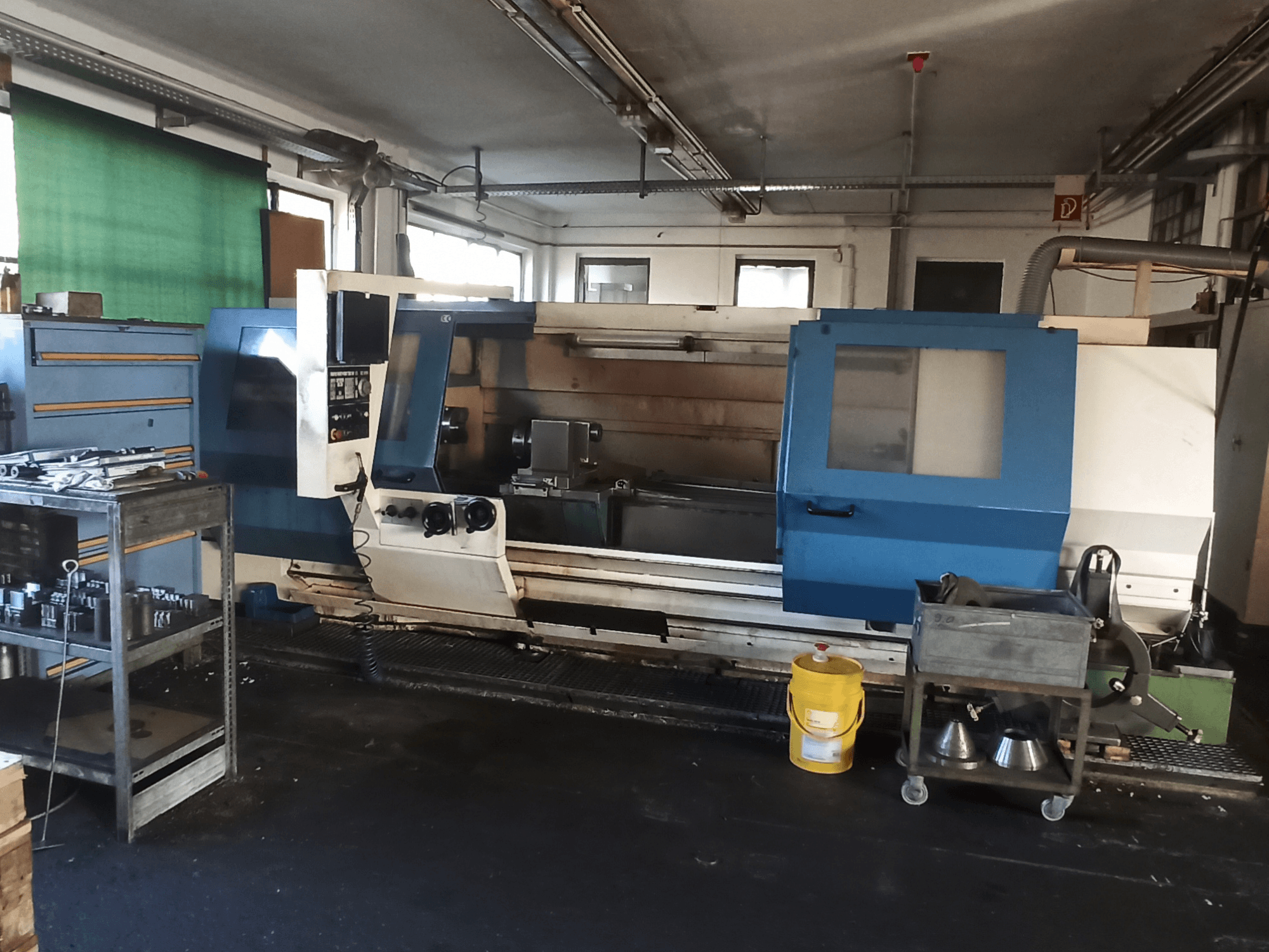 Den horisontella svarven BOEHRINGER DUC 560/2000 i en verkstad, med kontrollpanel och arbetsyta sedda från sidan.