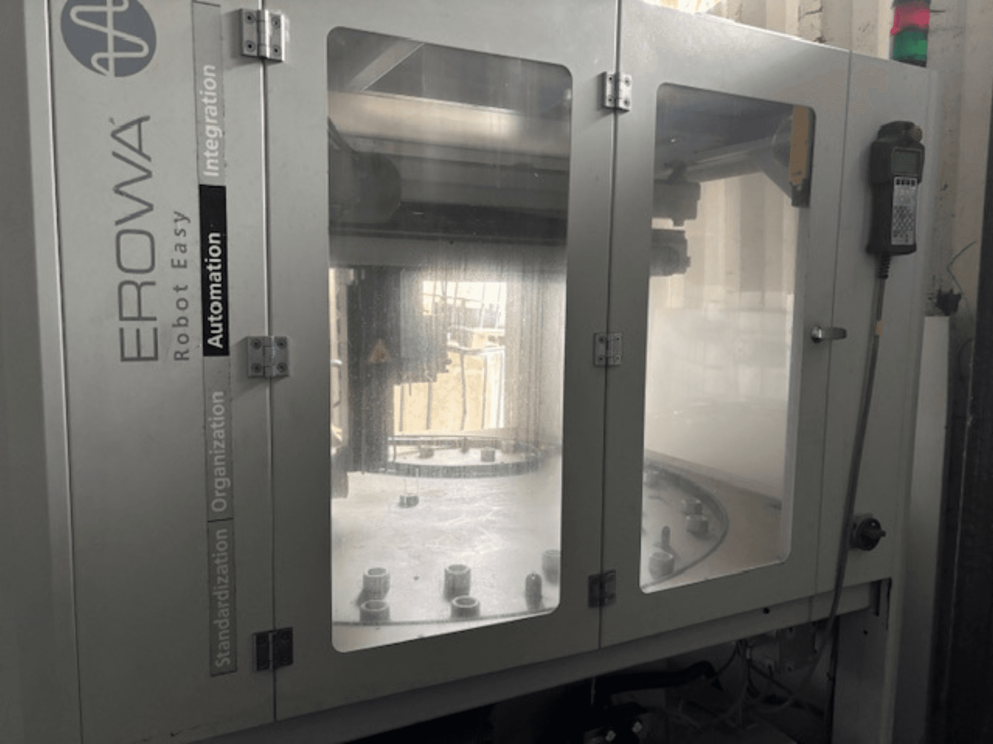 Frontvy av EROWA Robot Easy Automation; har tydliga dörrar, synliga automationskomponenter och kontrollpanel.