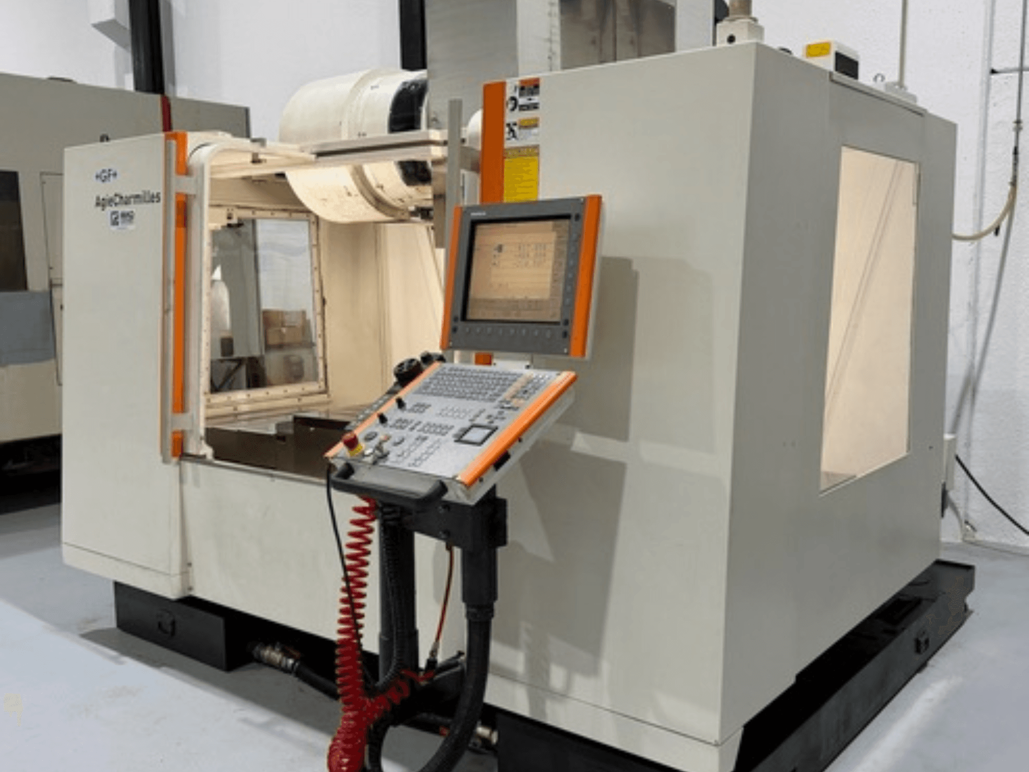 GF AgieCharmilles MIKRON-fräsmaskin i sidovy, med en kontrollpanel med knappar och en displayskärm.