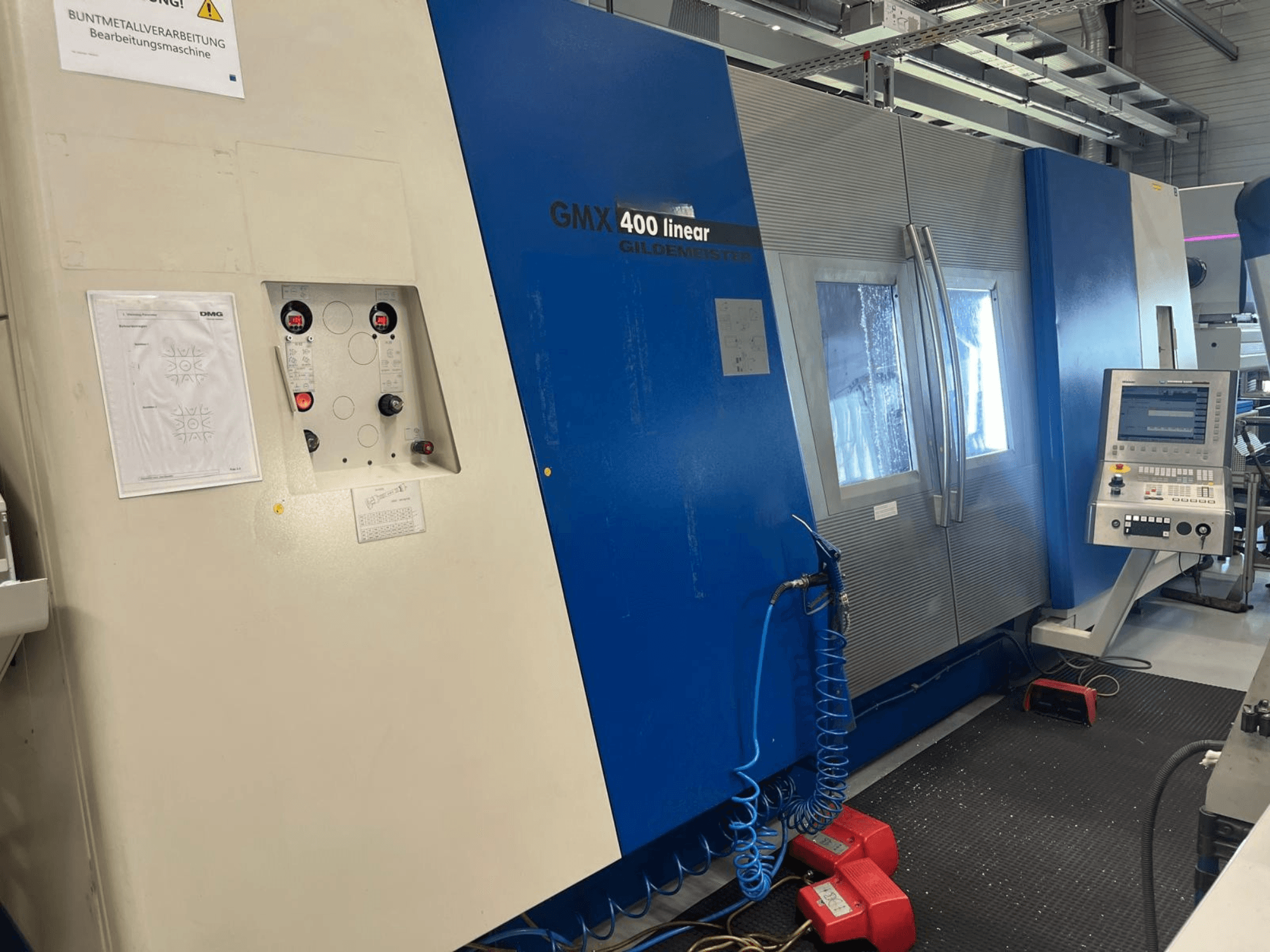 Gildemeister GMX 400 linjär svarv- och fräsmaskin, framifrån sett med kontrollpanel, kylsystem och manöverknappar.