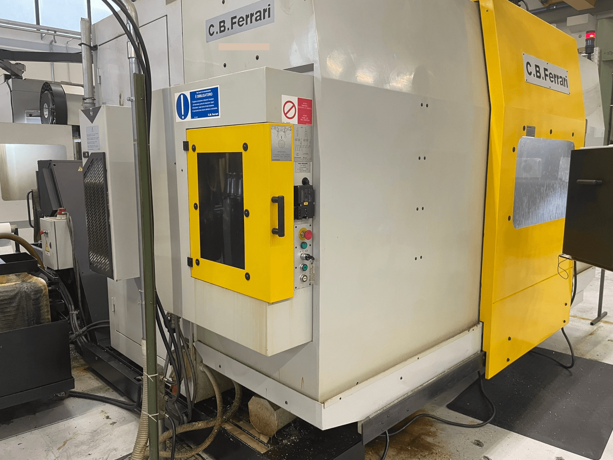C.B. Ferrari industrimaskin, framifrån; har gul dörr, kontrollpanel och synliga bearbetningskomponenter.