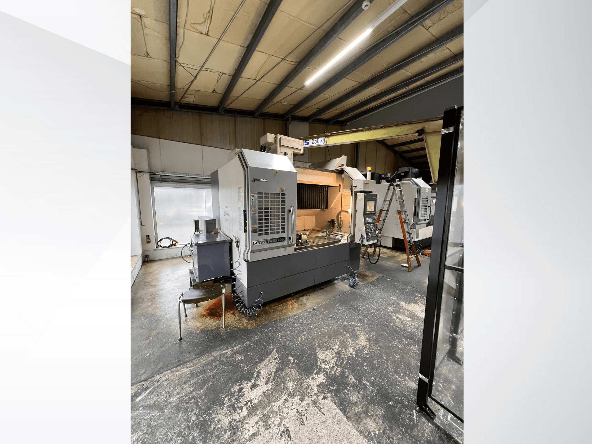 GRETOS 750 CNC-maskin i en verkstad, framifrån, med kontrollpanel och arbetsområde med verktyg, synlig stege i bakgrunden.