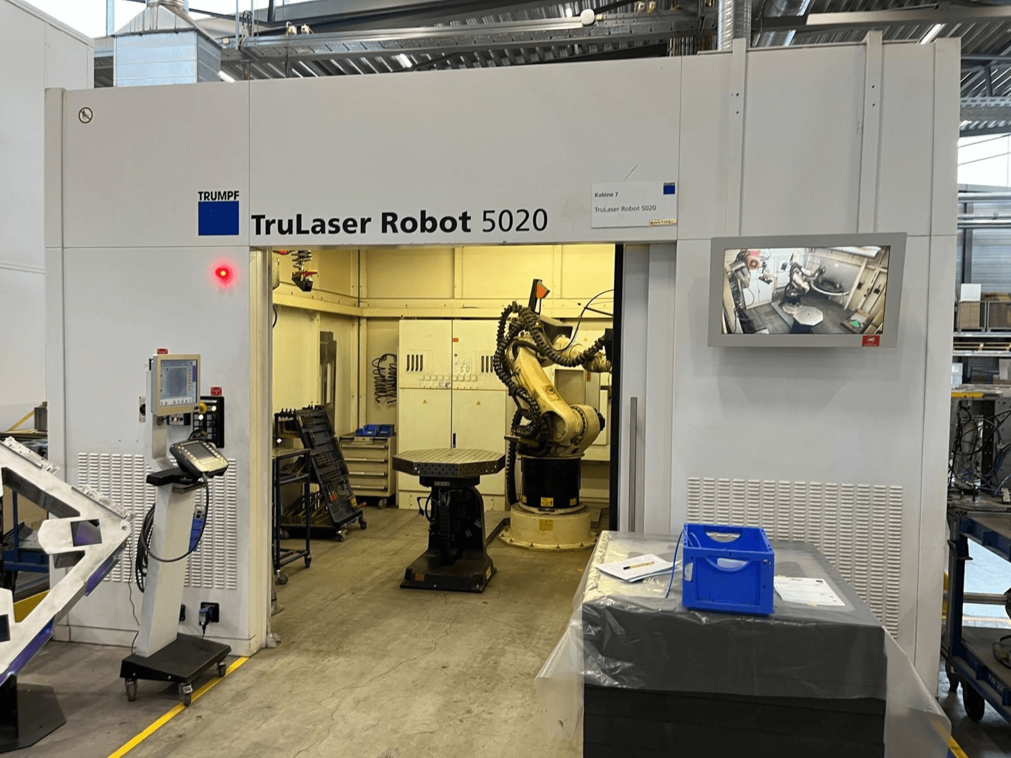 TRUMPF TruLaser Robot 5020 i en industriell miljö, med manöverpanel, robotarm och en skärm som visar driften.