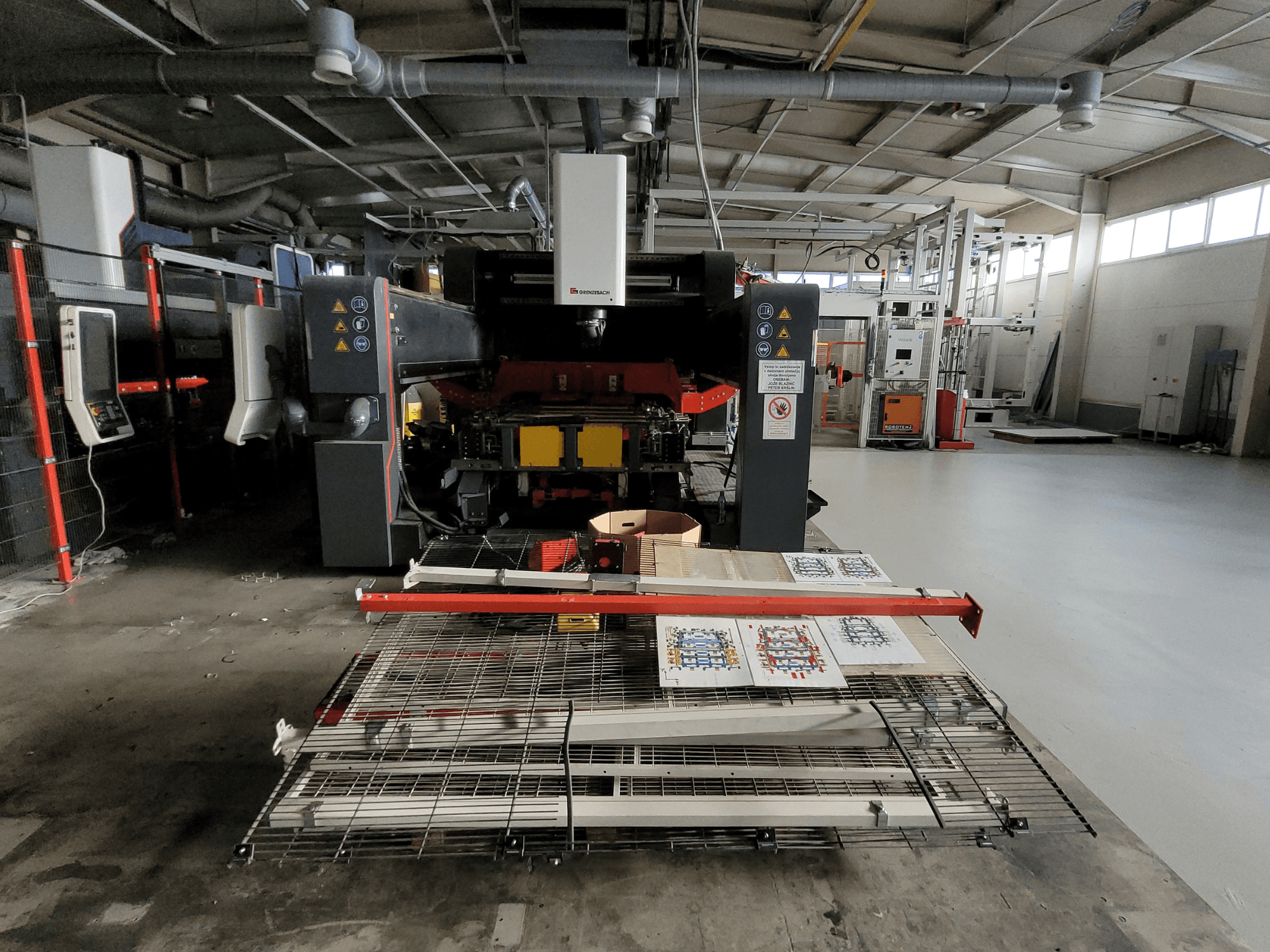 GRENZEBACH FSW-maskinen DSM 2400, framifrån i fabriksinställning, visar bearbetningsuppställningen med tryckt material och utrustning.