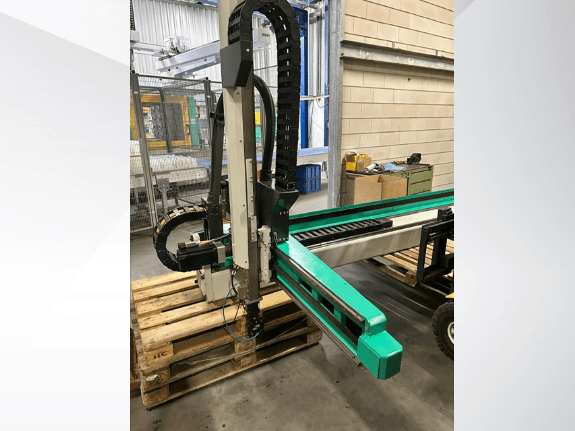 Arburg Multilift Select 15kg quer, sidovy av system för hantering av arbetsstycken på träpallar, visar robotarm och styrkomponenter.