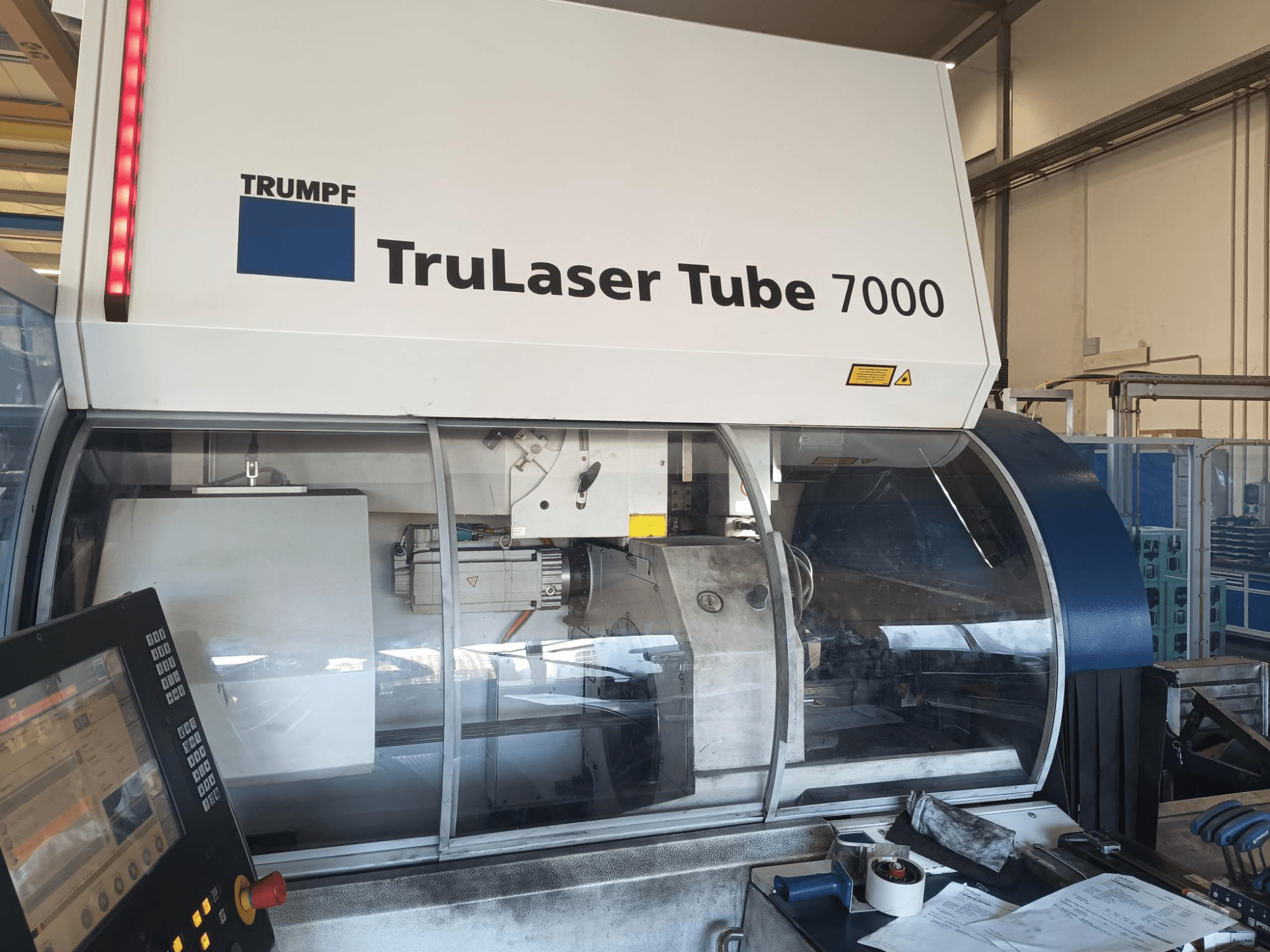 TRUMPF TruLaser Tube 7000, maskinens framsida med kontrollpanel, som visar laserskärningsfunktioner och arbetsyta.