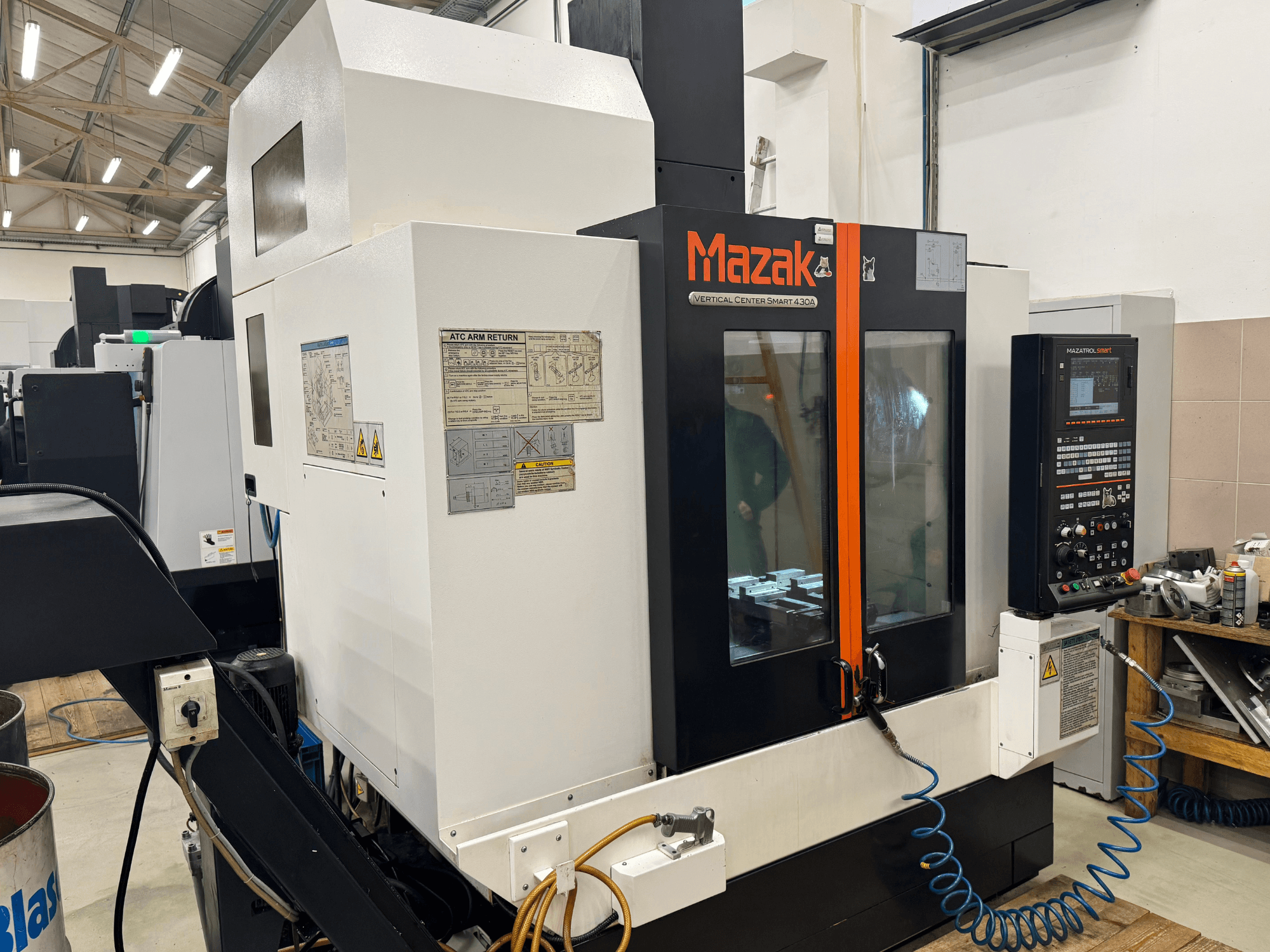 Mazak Vertical Center Smart 430A, framifrån; CNC-fräsmaskin med kontrollpanel, genomskinligt hölje och synlig verktygshållare.