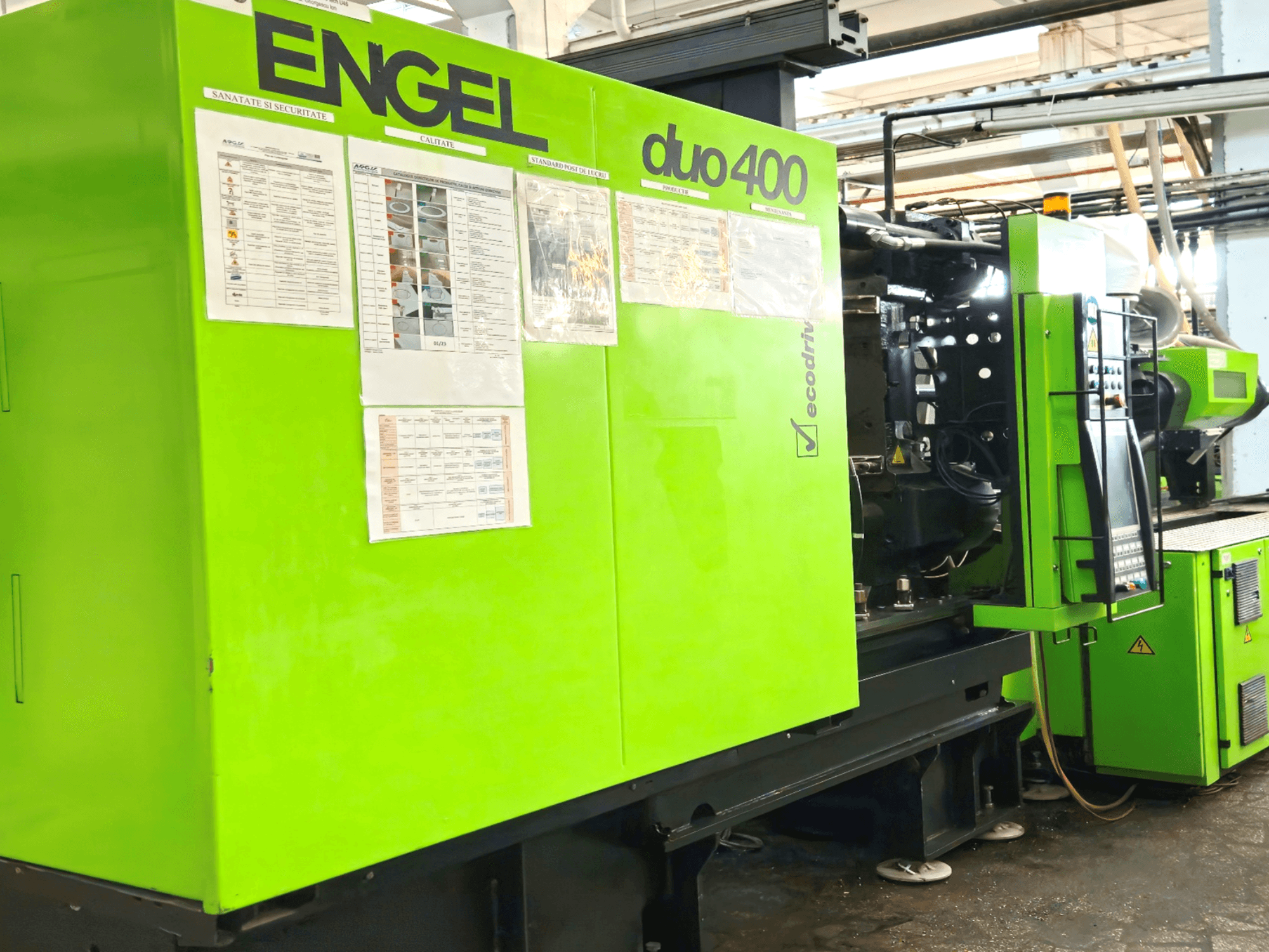 Grön ENGEL duo 400 formsprutningsmaskin, framifrån, med kontrollpanel och säkerhetsdokumentation på utsidan.