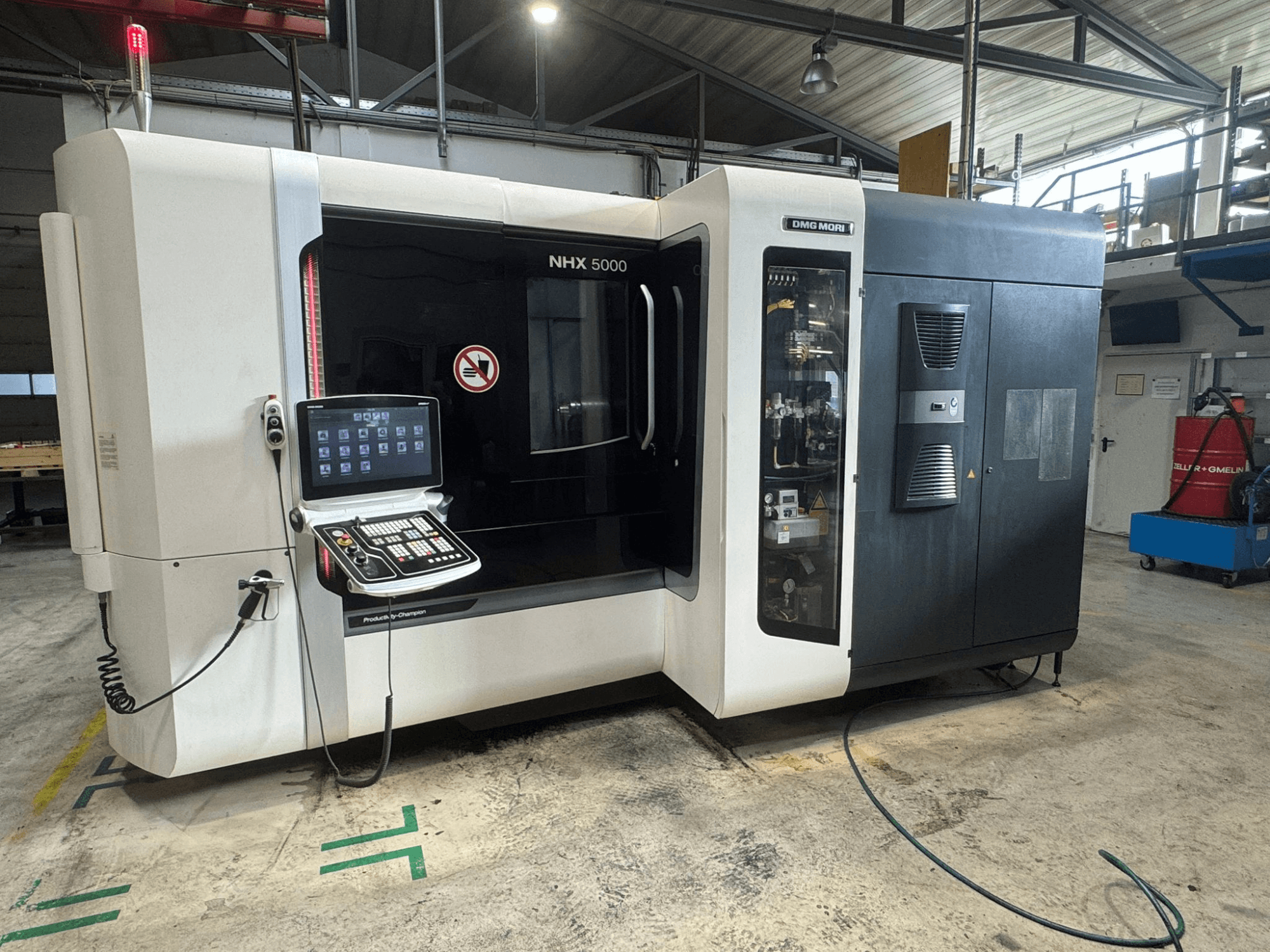 DMG MORI NHX 5000 horisontell fleroperationsmaskin, framifrån med synlig kontrollpanel och säkerhetsindikatorer.