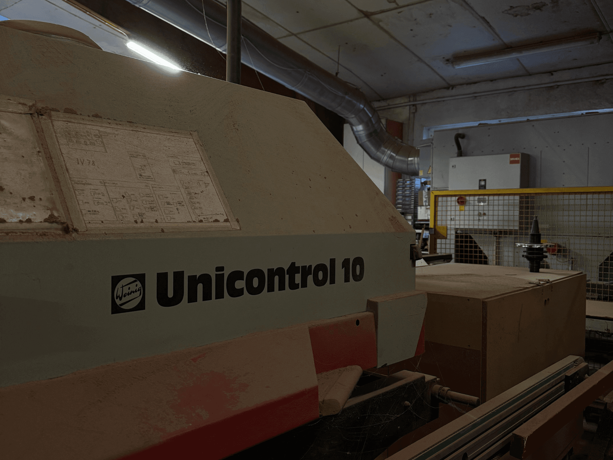 Weinig Unicontrol 10 maskin sedd från sidan, dammig yta, tekniskt schema synligt på frontpanelen.
