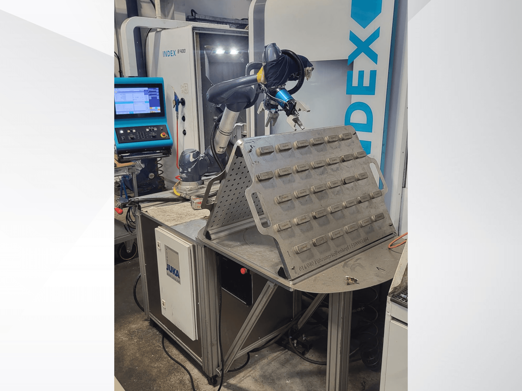 DOOSAN M1013 kollaborativ robot framifrån, placerad nära ett arbetsbord med verktygshållare och kontrollpanel.