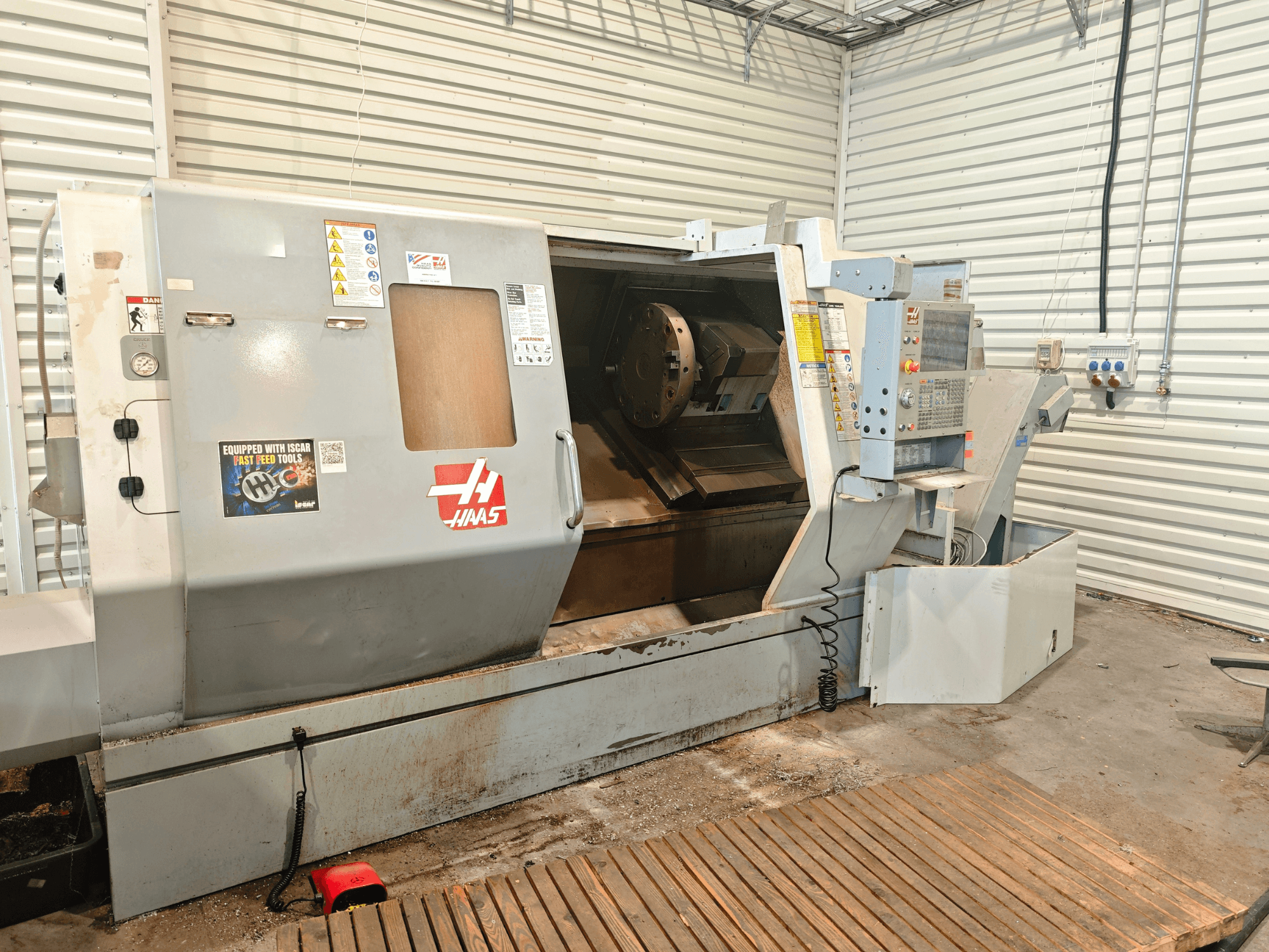 Haas SL-40HE horisontell svarv, framifrån, där man ser kontrollpanelen, arbetsområdet och säkerhetsmärkningar.