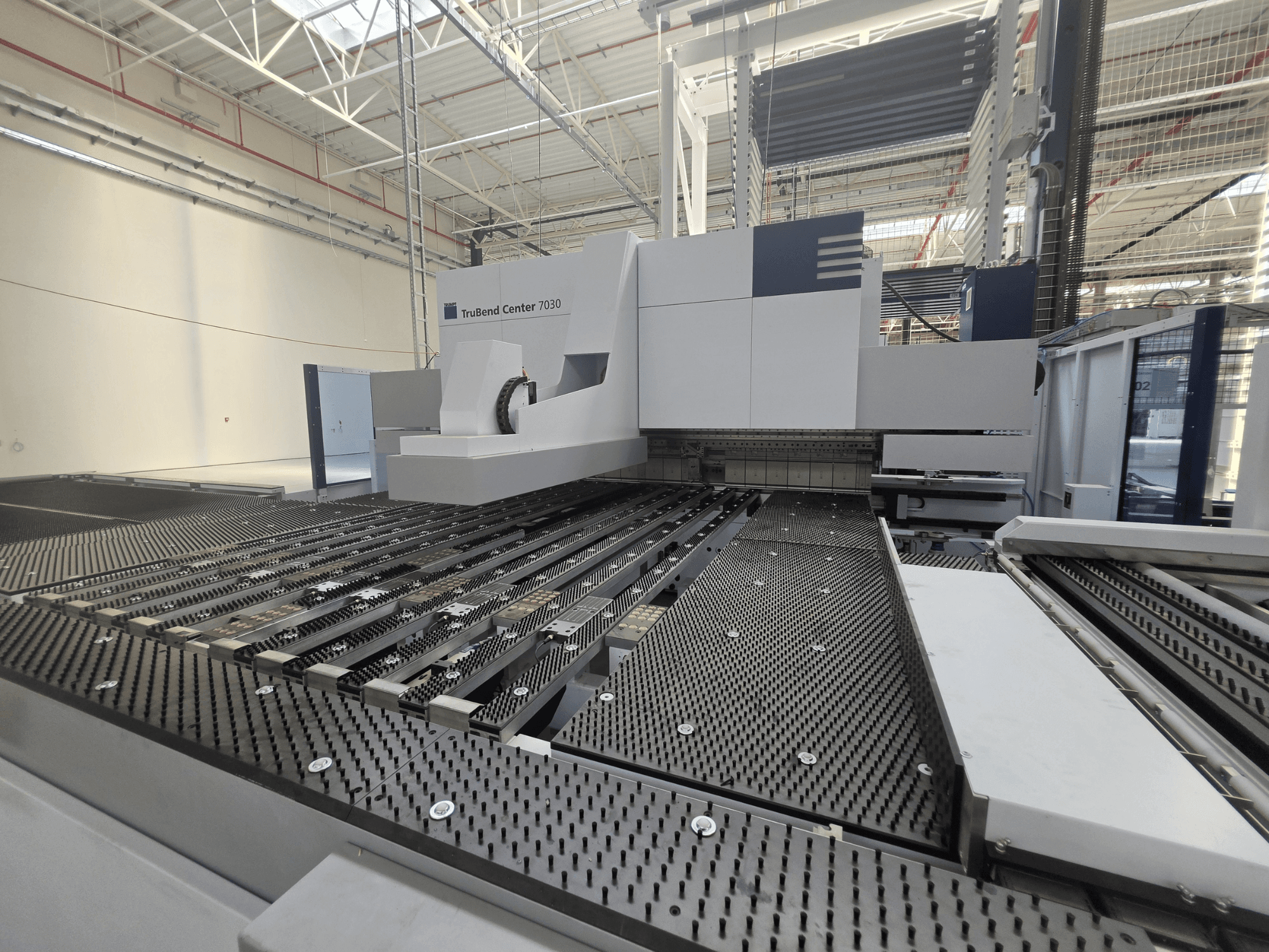 TRUMPF TruBend Center 7030 bockningsmaskin i en fabriksmiljö, framifrån sett med det sofistikerade arbetsbordet och bockningsarmen.