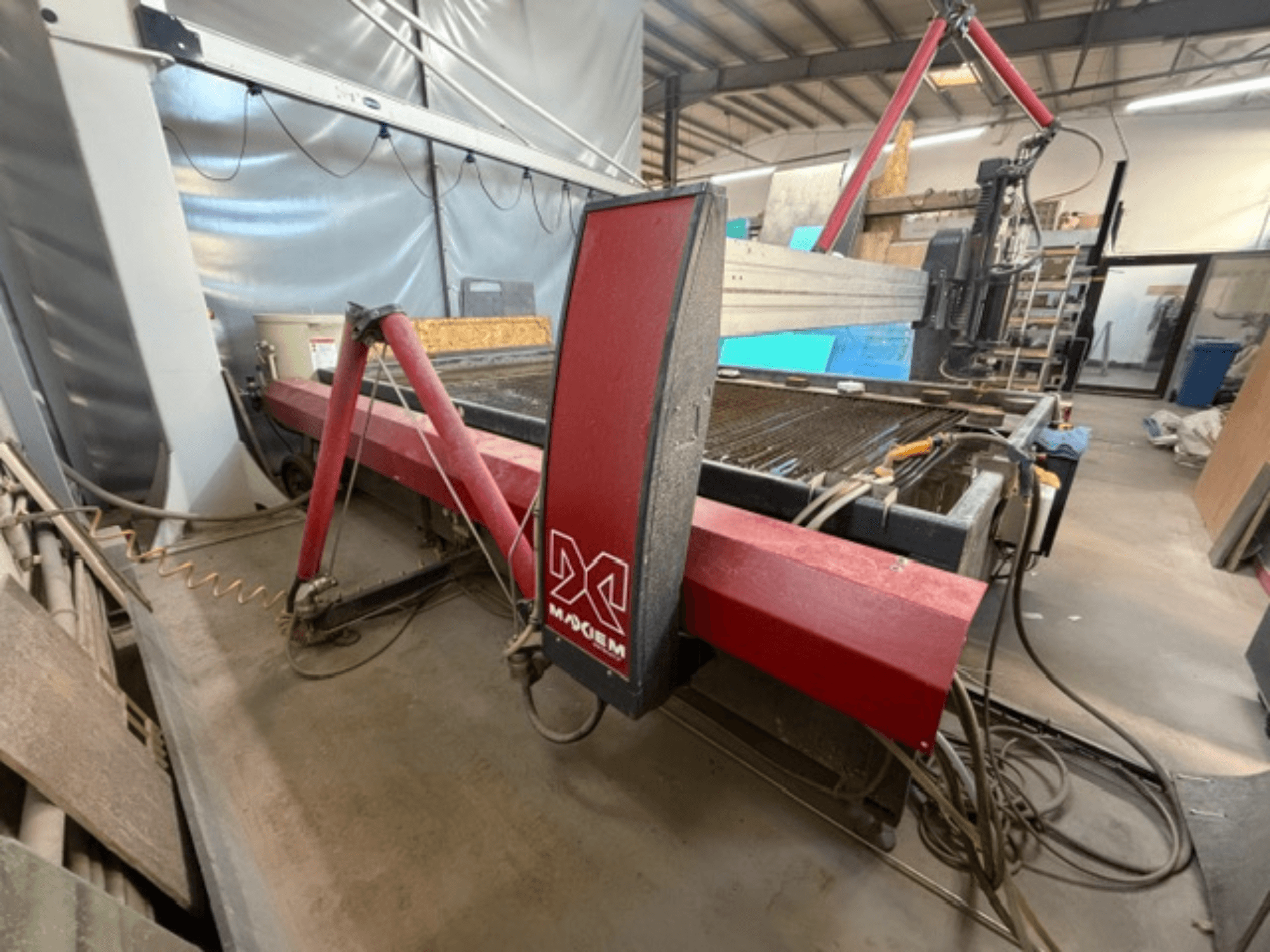 Röd vattenskärningsmaskin från märket X, sedd från sidan, med mekaniska komponenter och rördetaljer.