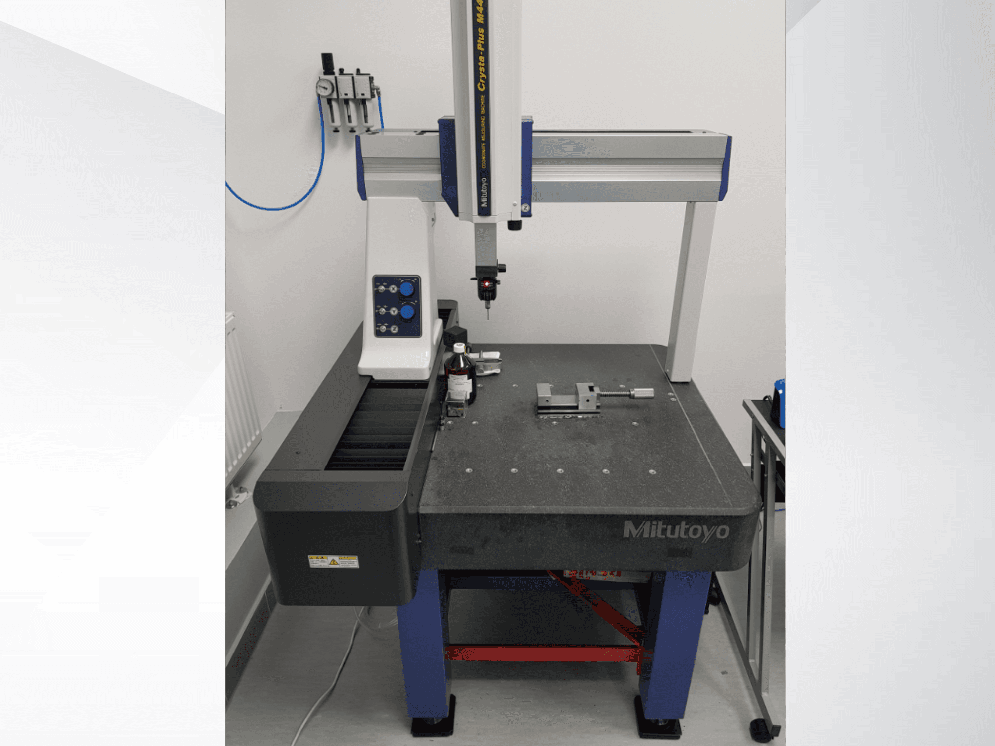 Mitutoyo Crysta-Plus M443 CMM sett framifrån, med mätprob, kontrollpanel och mätbord med fixturer.
