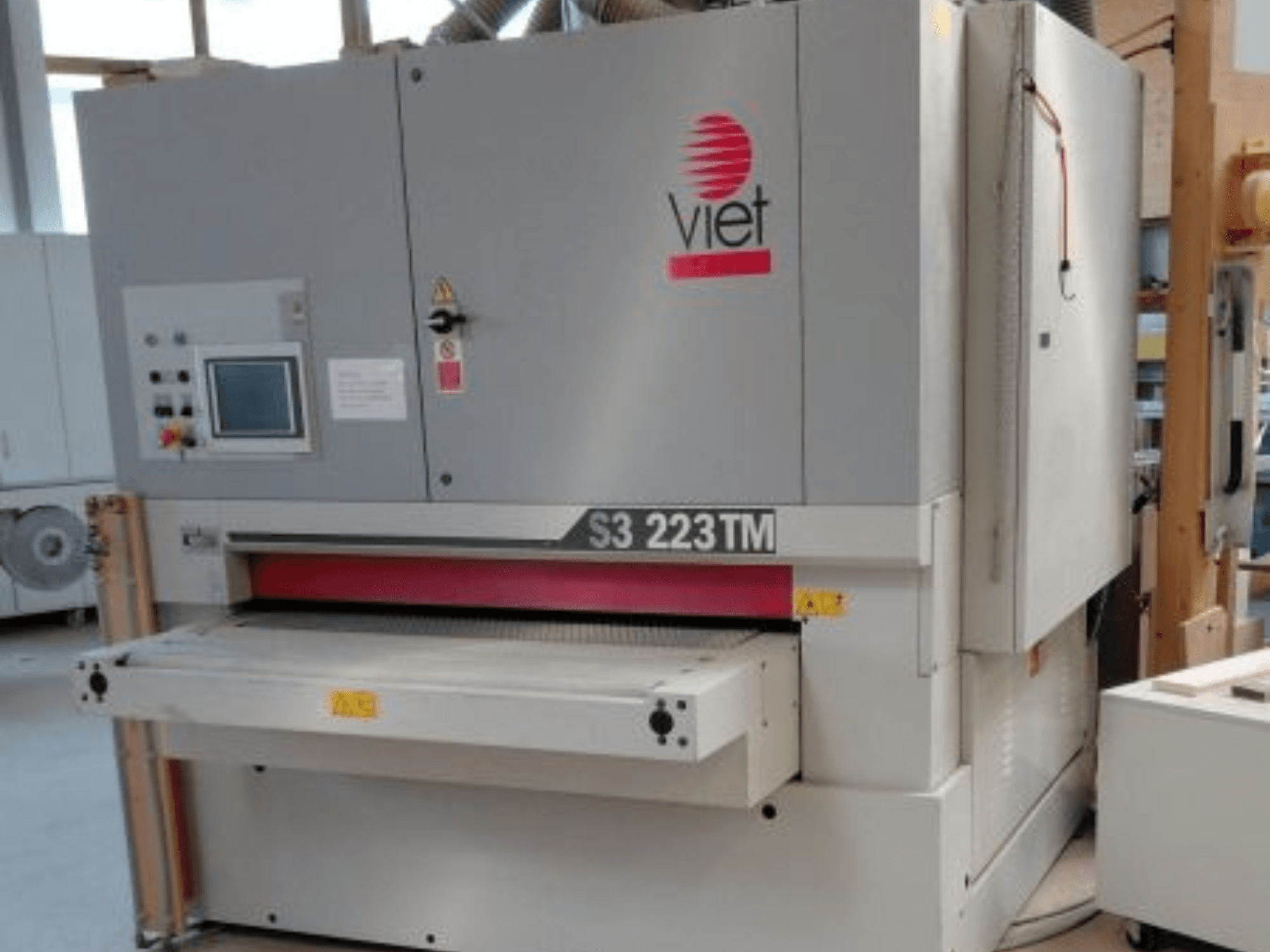 Bandslipmaskinen VIET S3 223TM sedd framifrån, med kontrollpanel, slipbänk och säkerhetsmärkningar.