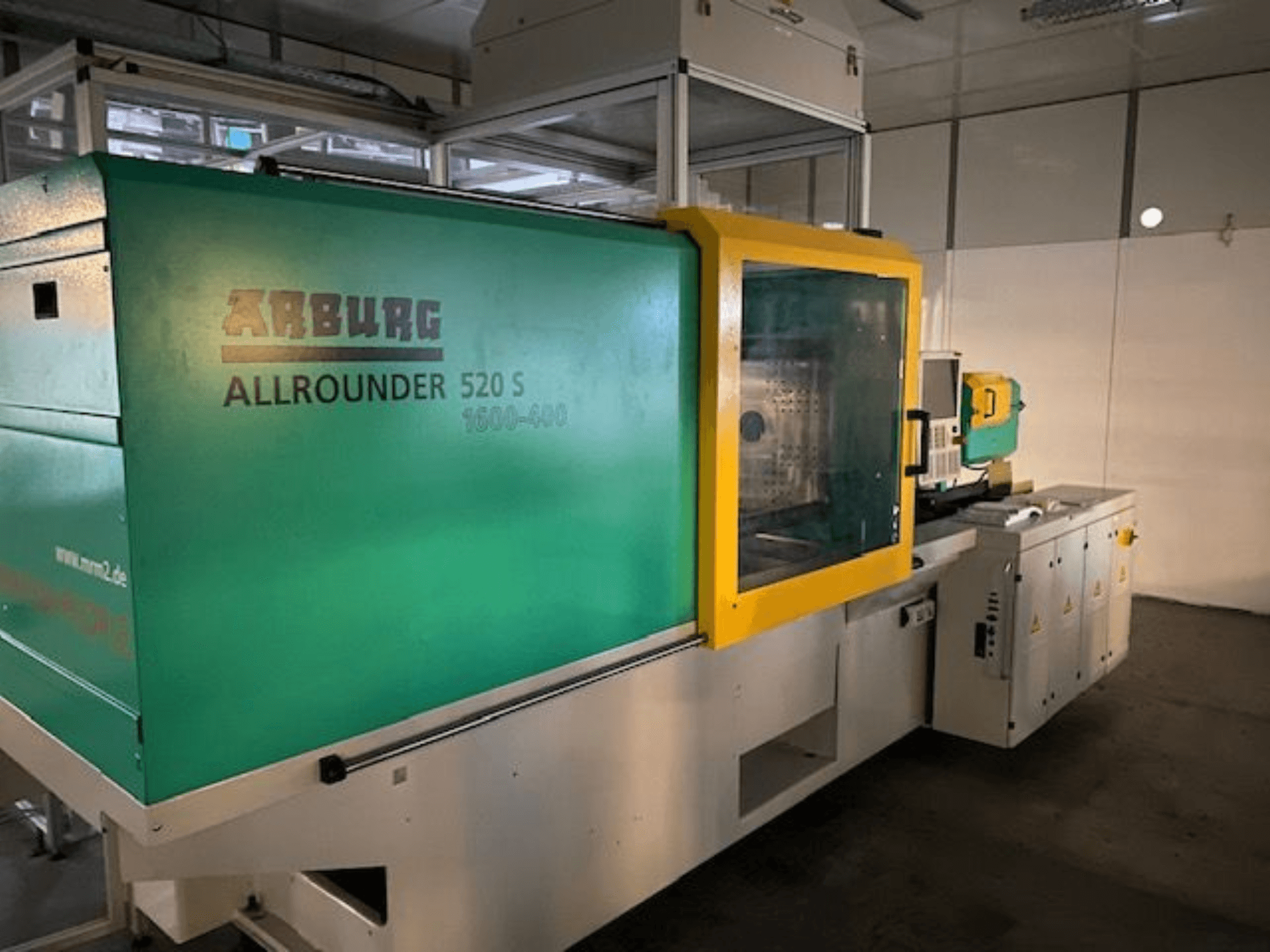 Arburg Allrounder 520 S formsprutningsmaskin, vy från sidan, med grön och gul exteriör, tekniska detaljer synliga.