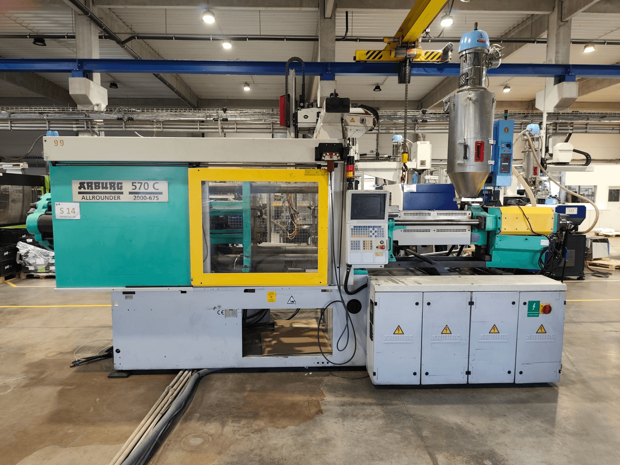 Hydraulisk formsprutningsmaskin Arburg Allrounder 570 C 2000-675, sett framifrån, med kontrollpanel och materialbehållare.