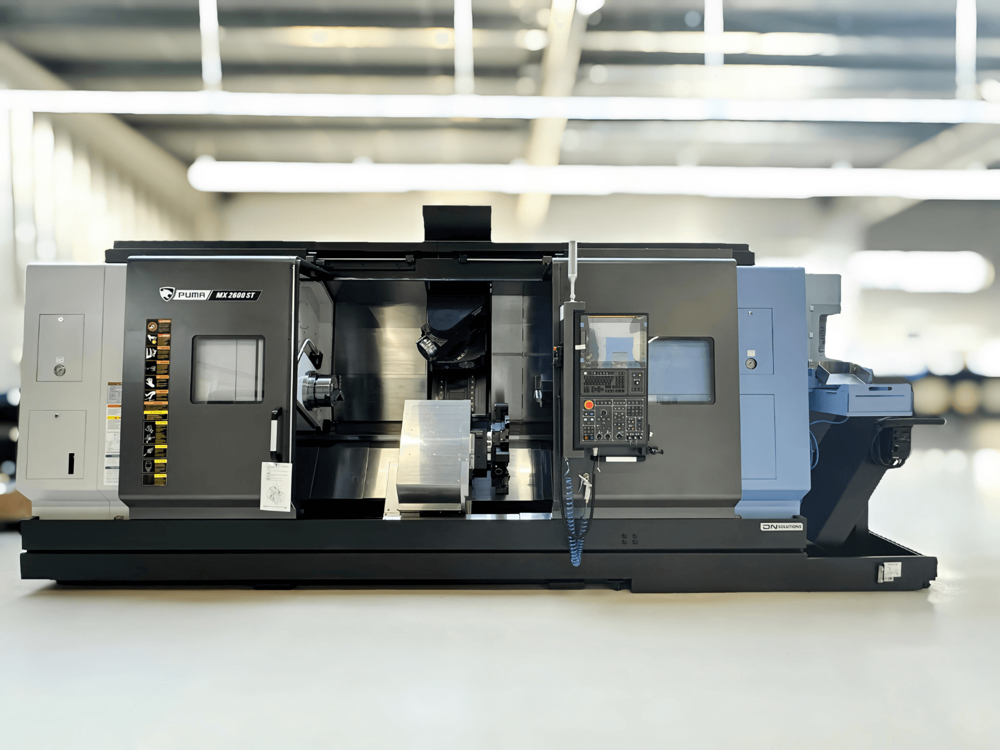 Puma MX2600ST Mill-Turn Centre i sidovy, med detaljerad kontrollpanel och bearbetningsområde med synliga verktyg.