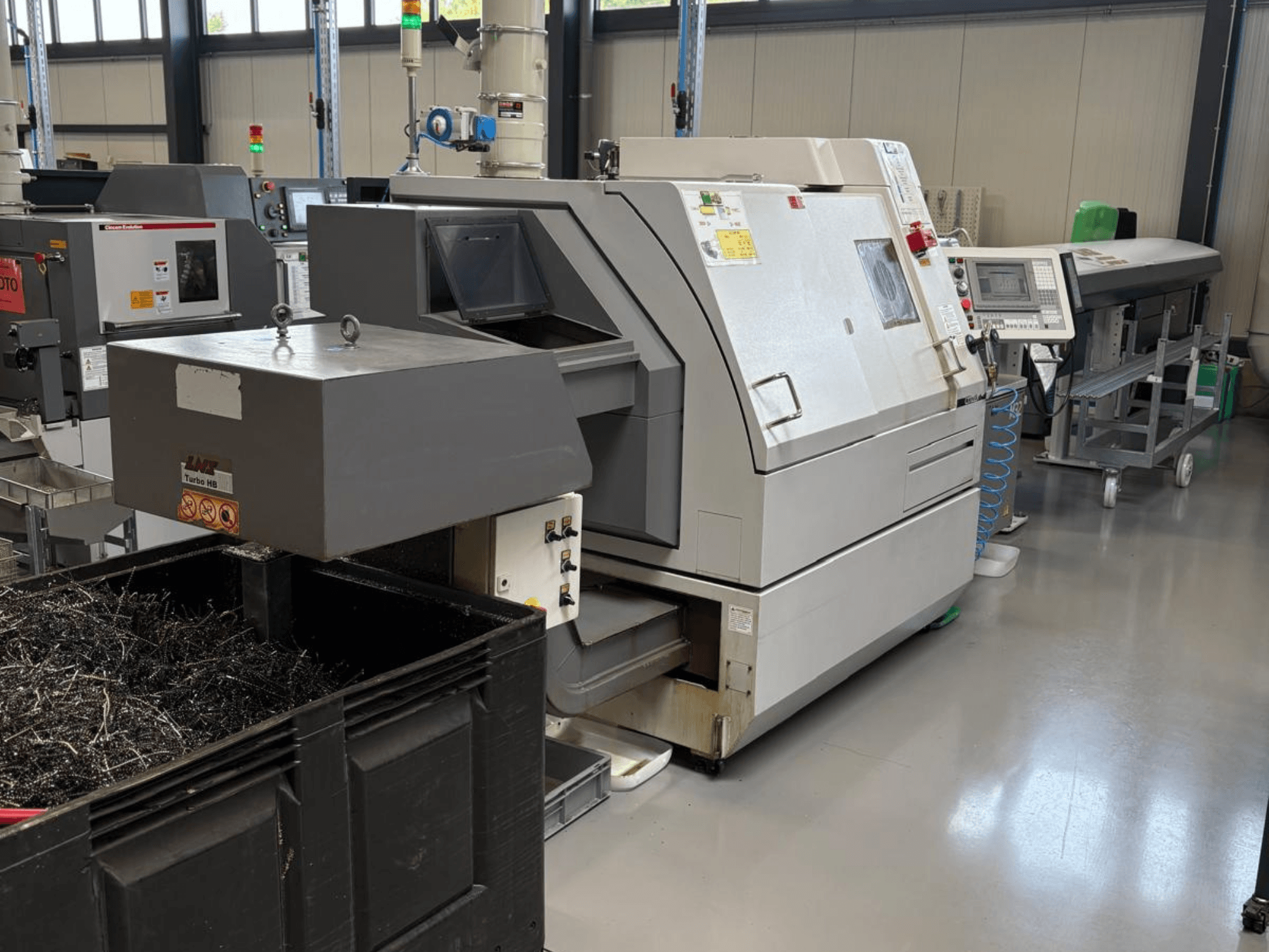 LTA Turbo H8 industrimaskin, vy från sidan, med en stor behållare för metallspån och kontrollpanel i en fabriksmiljö.