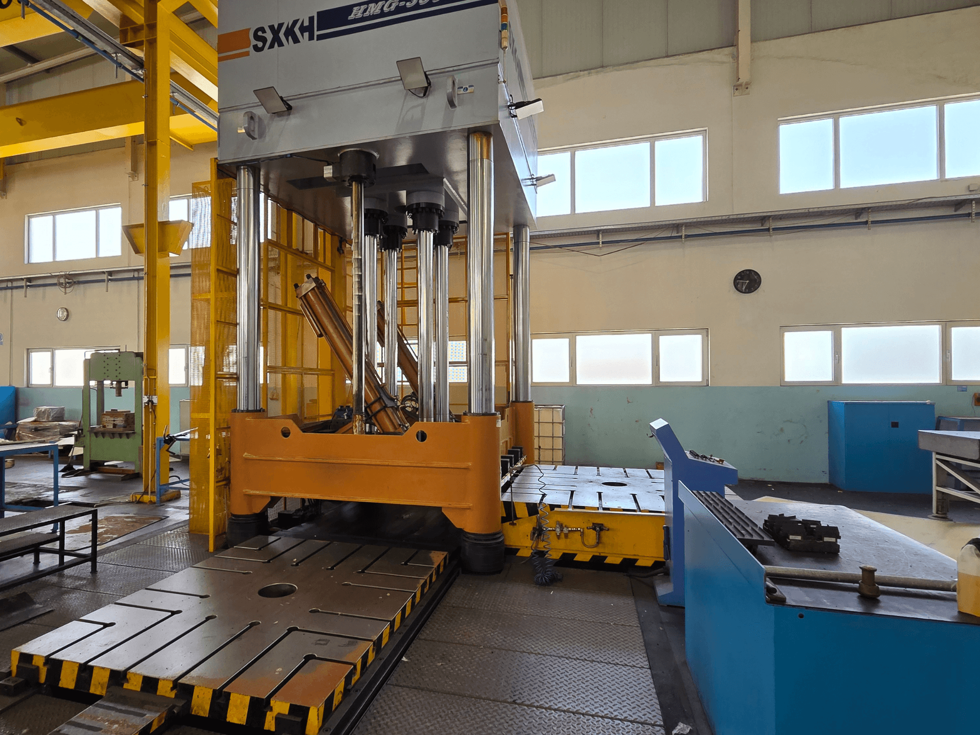 Hydraulpress SXKH HMG-300JM framifrån, med stora presscylindrar och en robust bas i en fabriksmiljö.