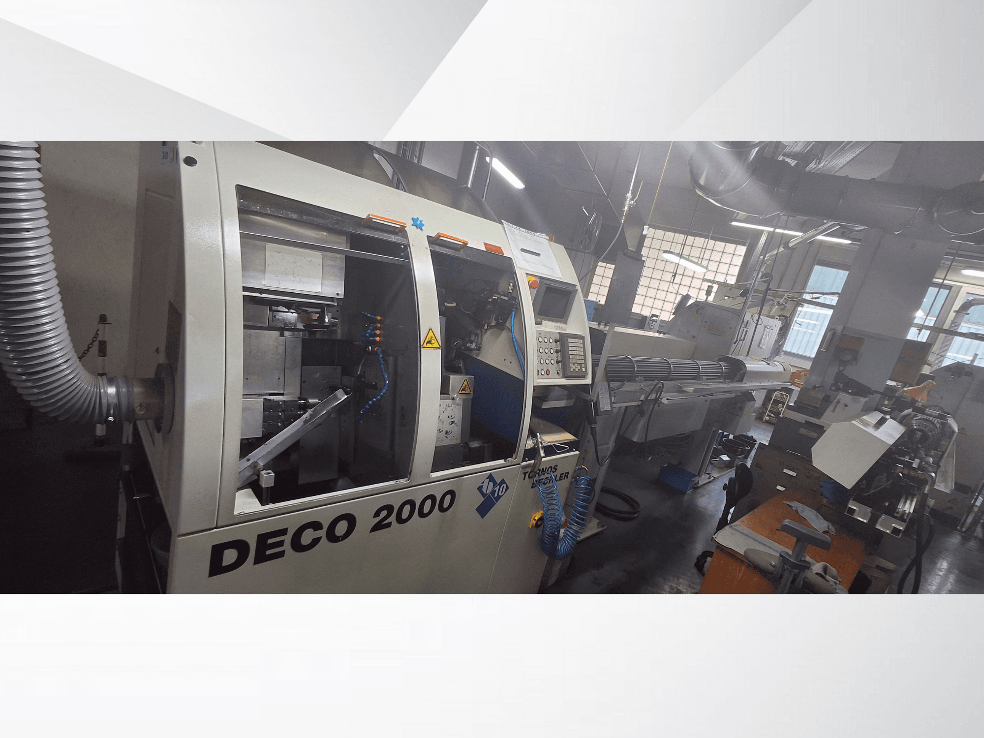 DECO 2000 CNC-maskin i en verkstad, vy framifrån, med reglage och en uppställning för långa arbetsstycken till höger.