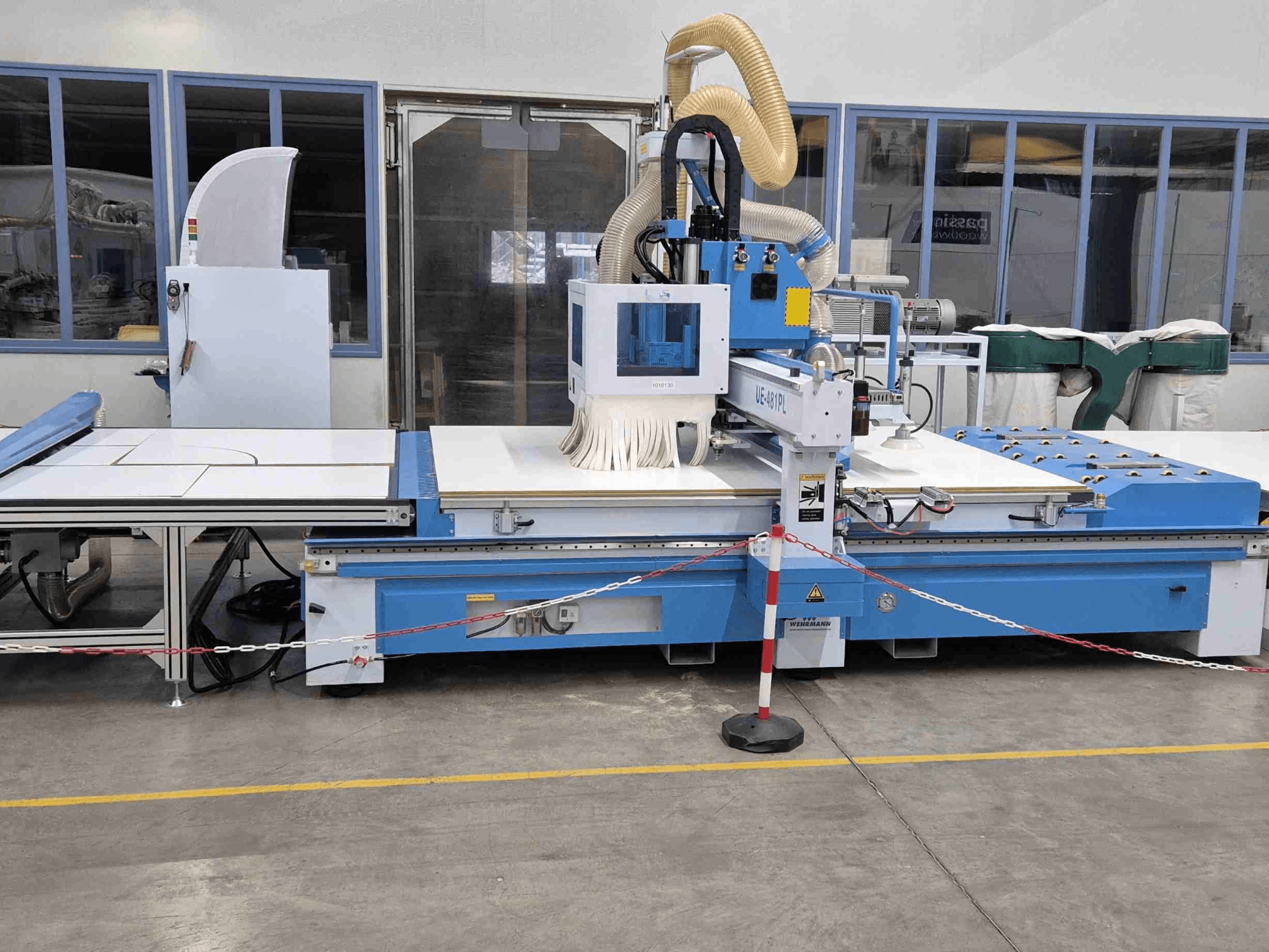 Blå CNC-router UE-621PL framifrån, med stort skärbord och anslutet dammutsugssystem.