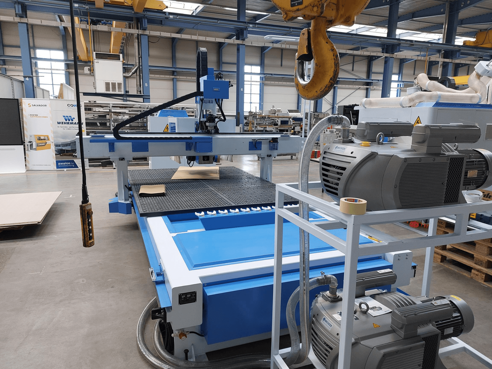 CNC-bearbetningscenter för trä QUICK CNC UA 481, framifrån med kontrollpanelen, motorerna och arbetsytan med ett trästycke.